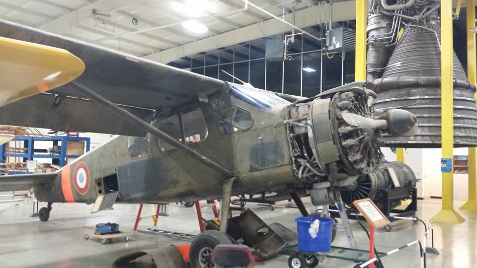 An old prop plane with its engine open at the Air Zoo