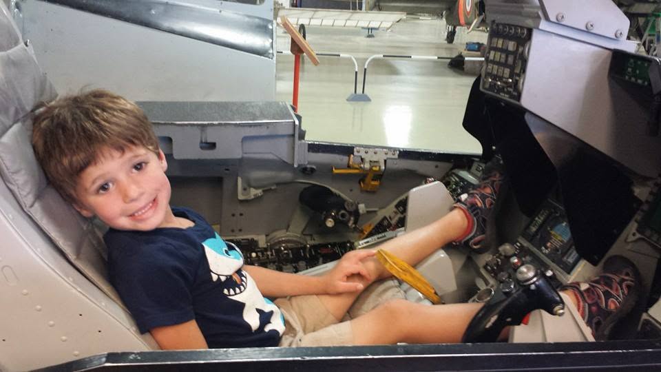 Thomas in a jet cockpit with his feet up