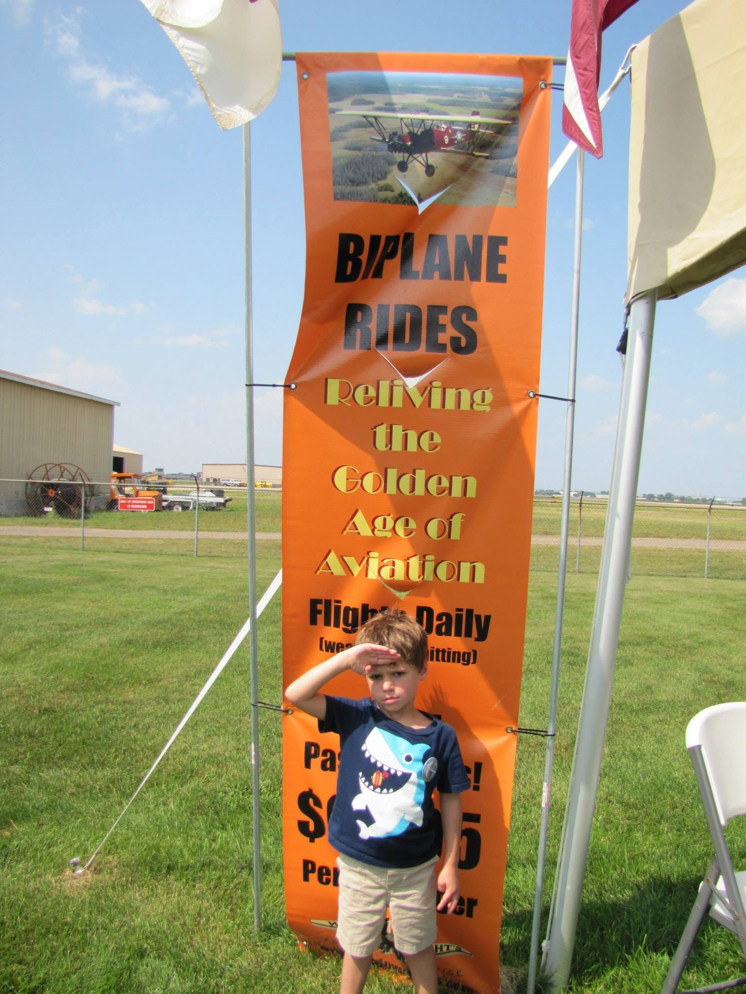 Thomas saluting at the biplane rides banner