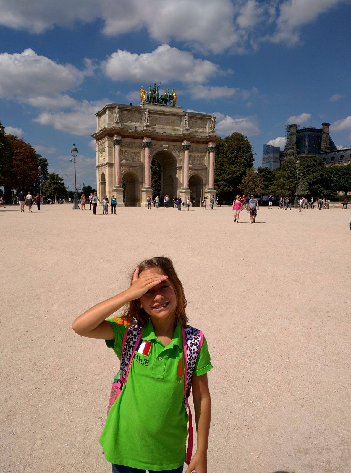 Lisa shading her eyes by the Carrousel arch