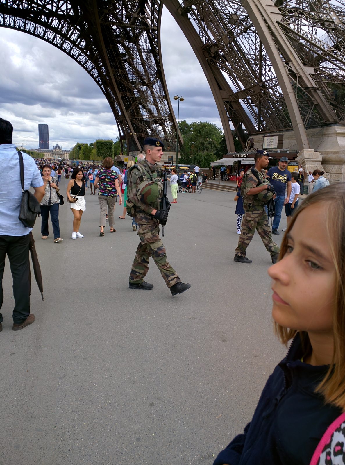 Lisa watching soldiers patrol under the Eiffel Tower