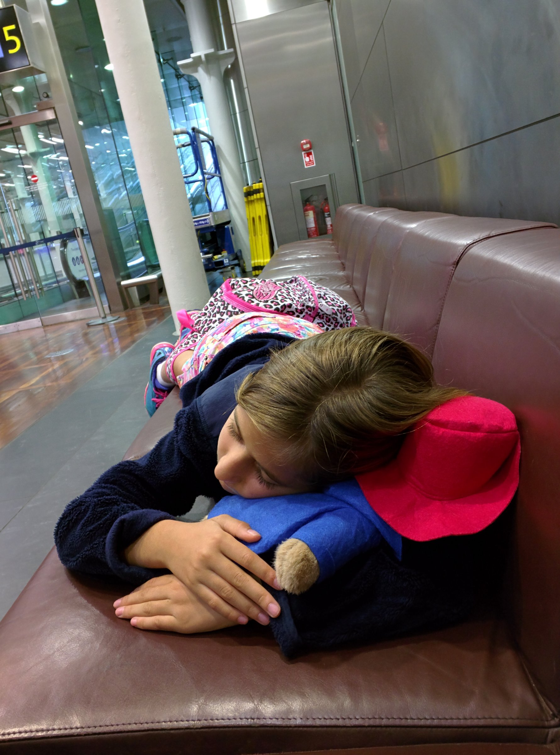 Lisa asleep on the bench with Paddington