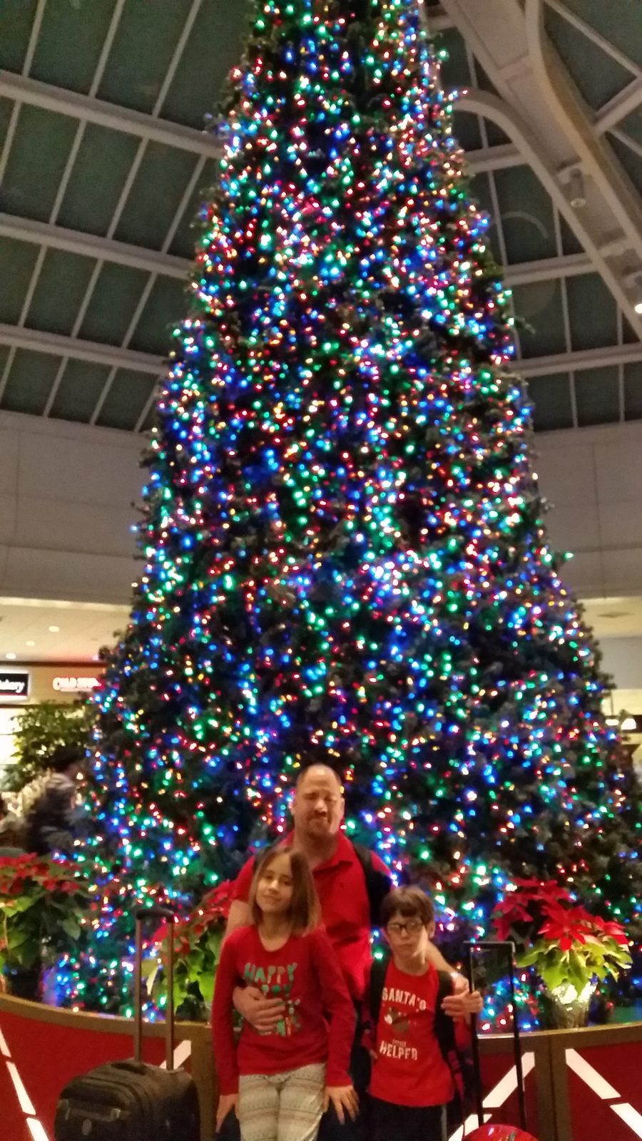 The three of us under the Christmas tree at the airport
