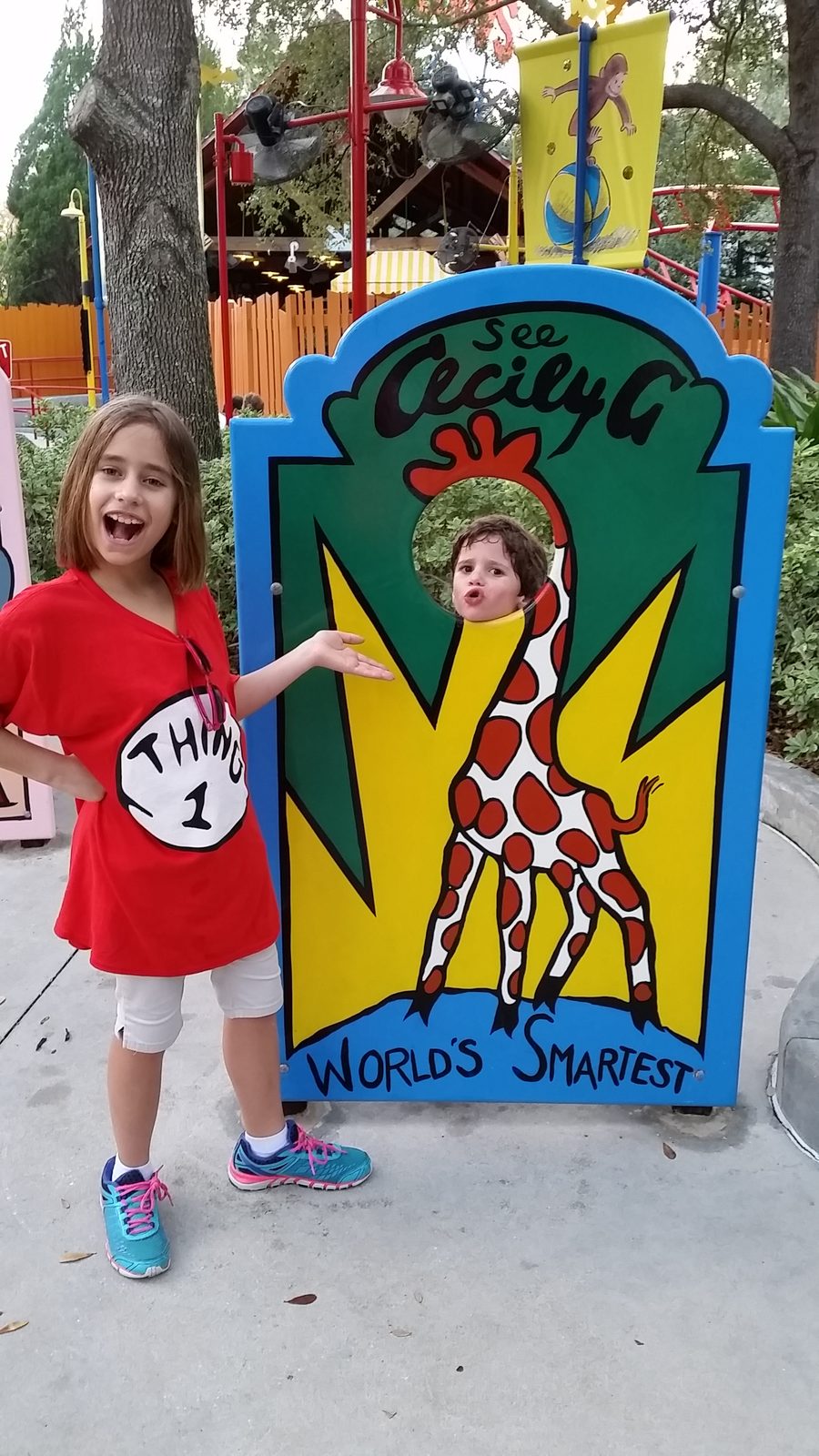 Lisa and Thomas with the giraffe cutout at Seuss Landing