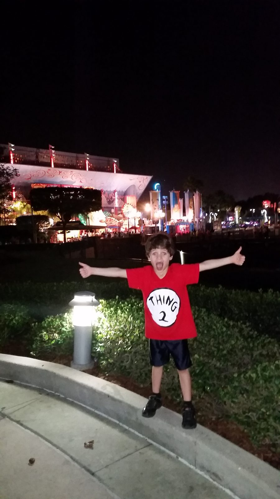 Thomas arms wide at Universal Studios after dark