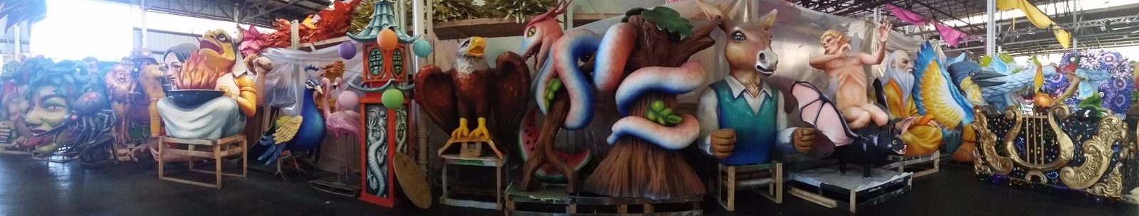 Rows of parade floats waiting inside Mardi Gras World