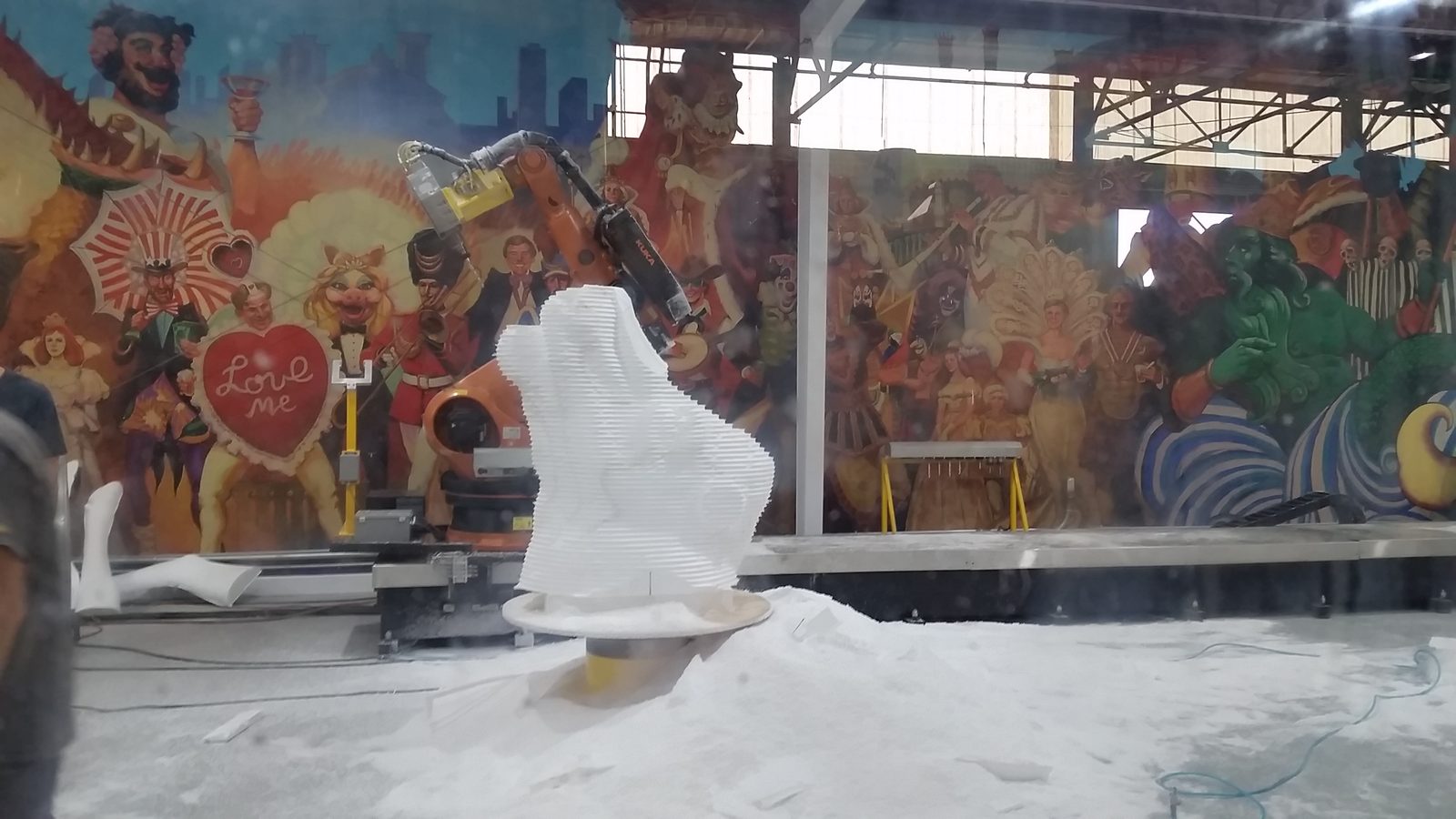A machine carving a foam figure at Mardi Gras World