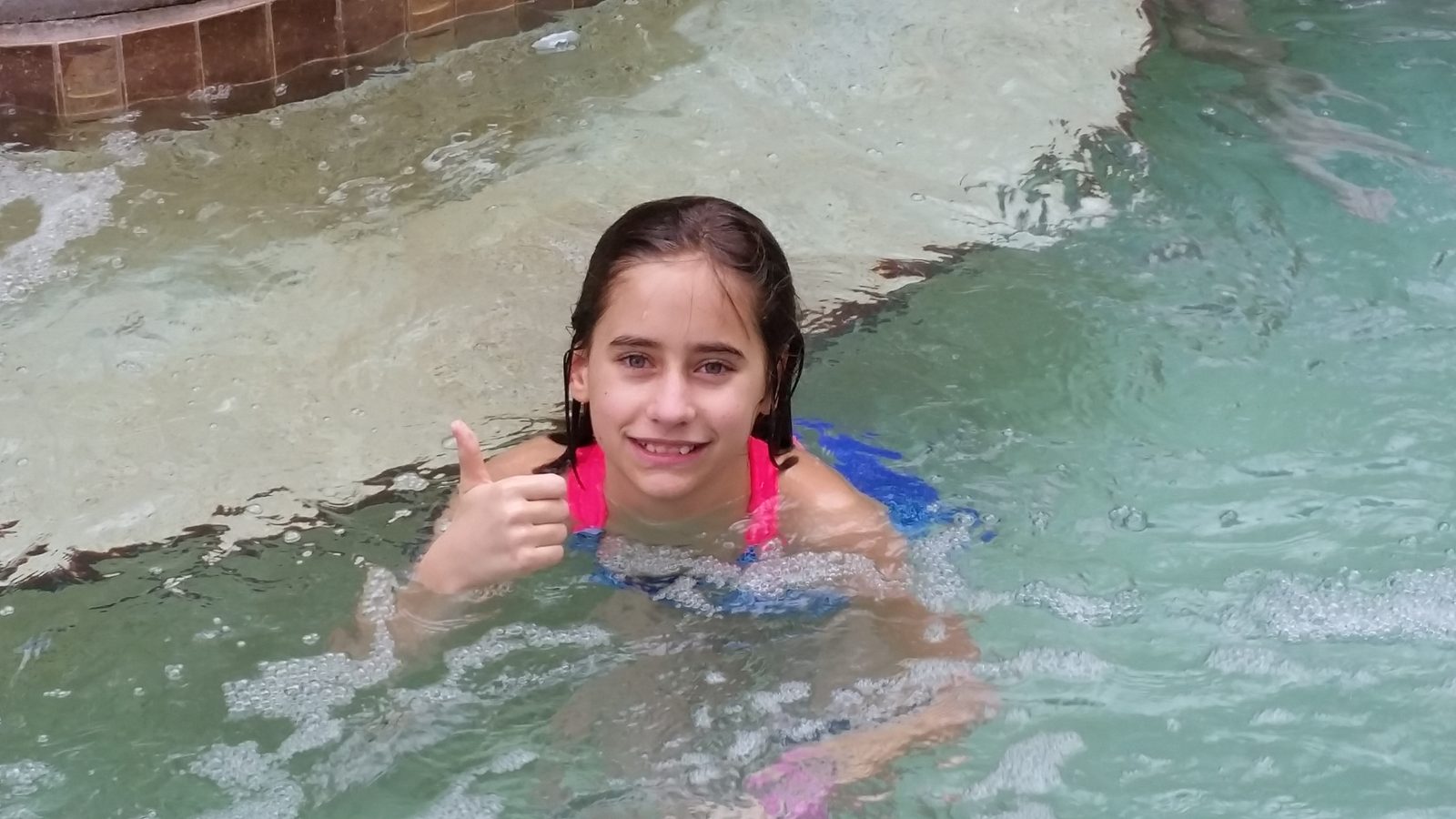 Lisa's thumbs up in the lodge pool