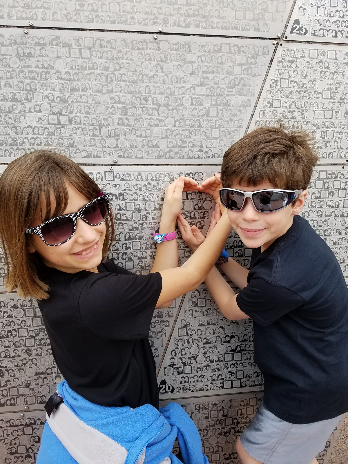 Lisa and Thomas making a heart at the Leave a Legacy wall