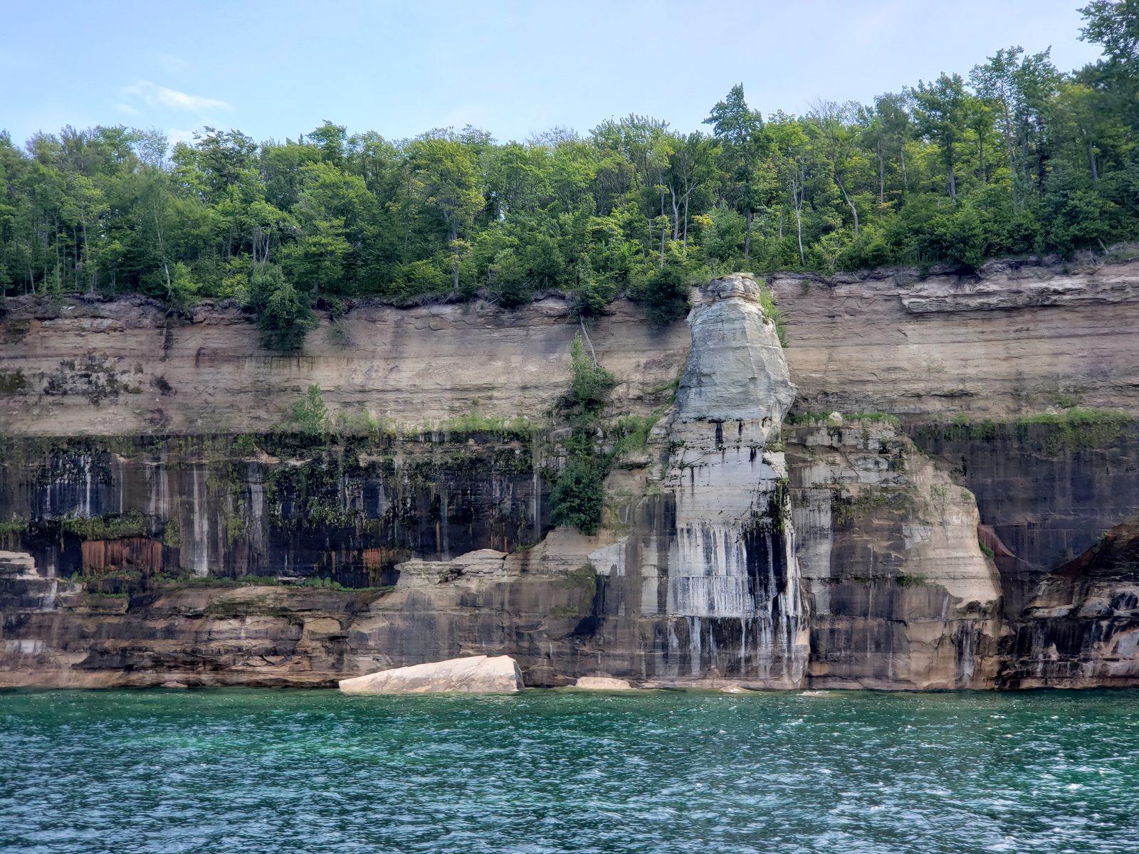 Streaked cliffs and a rock pillar from the boat
