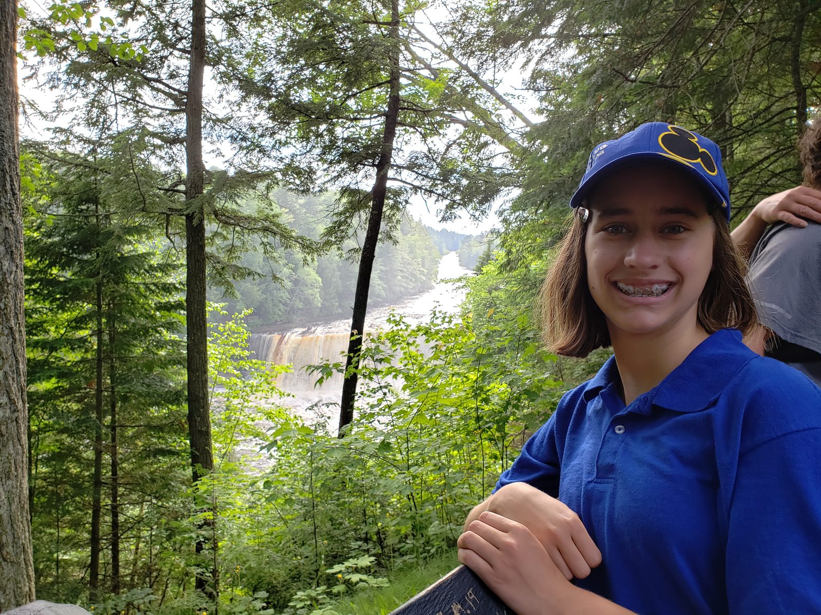 Lisa at a Tahquamenon lookout, falls through the trees