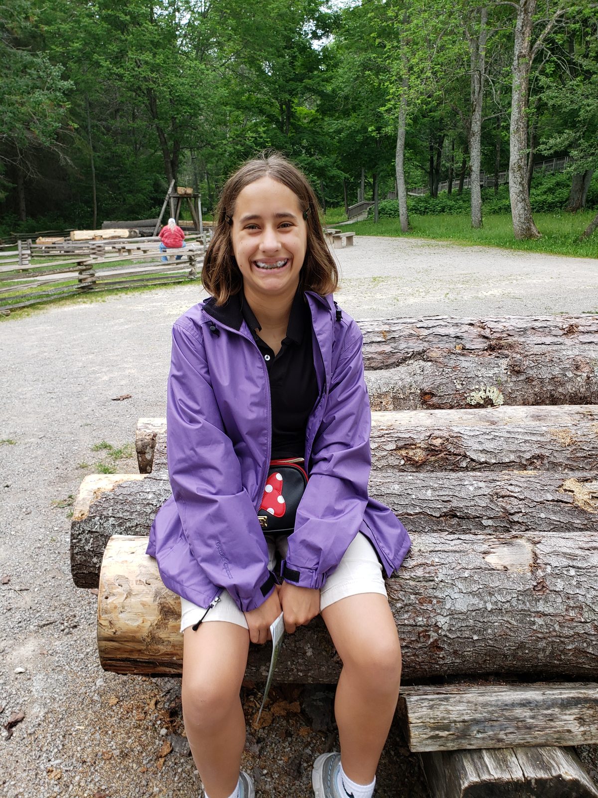 Lisa sitting on the log pile at Mill Creek