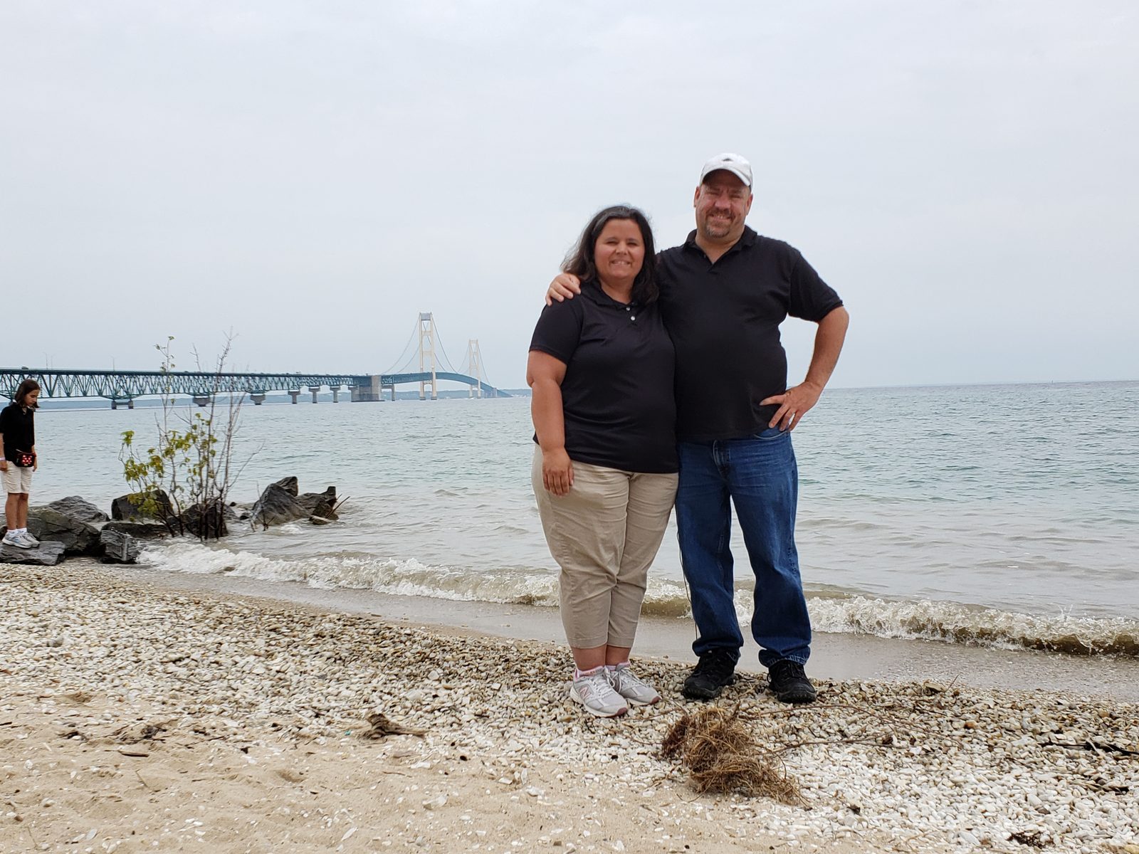 Kathy and Michael on the beach with the bridge