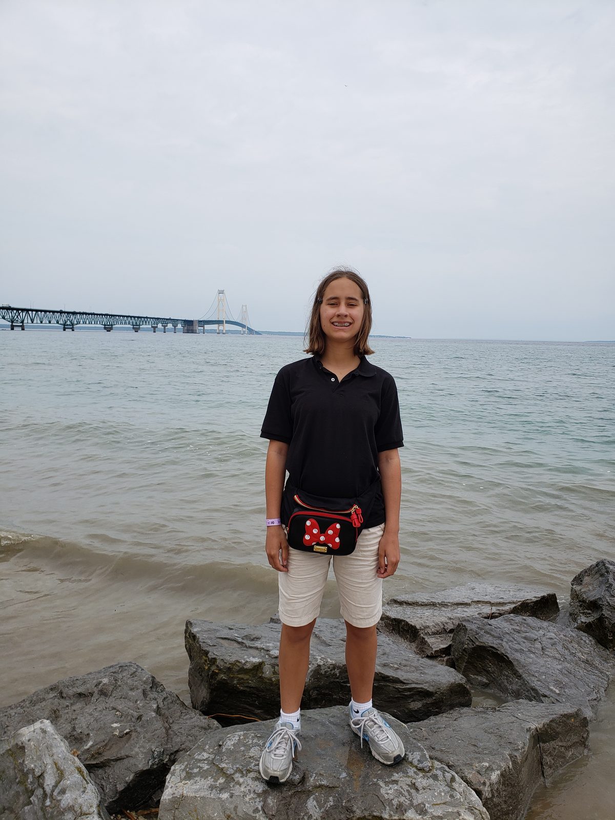 Lisa on the rocks by the lighthouse, bridge in the distance