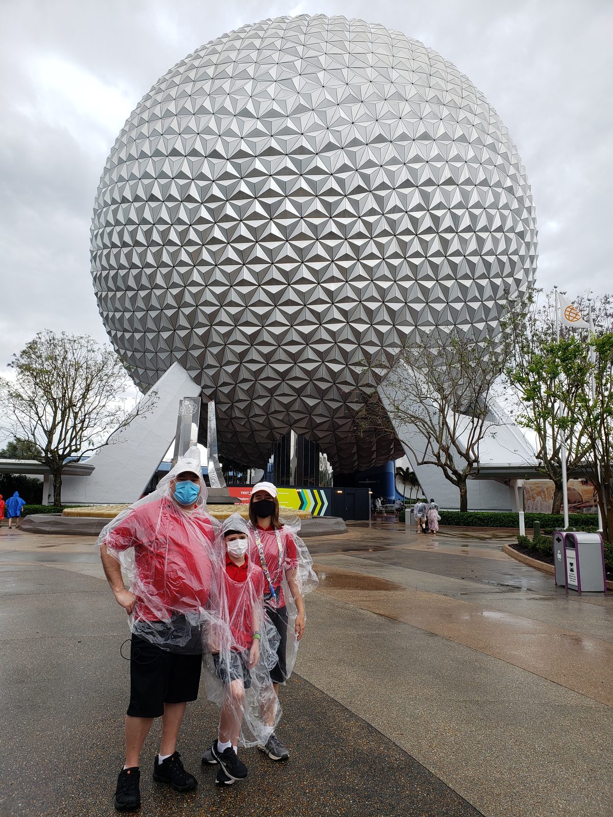 The four of us in ponchos under Spaceship Earth
