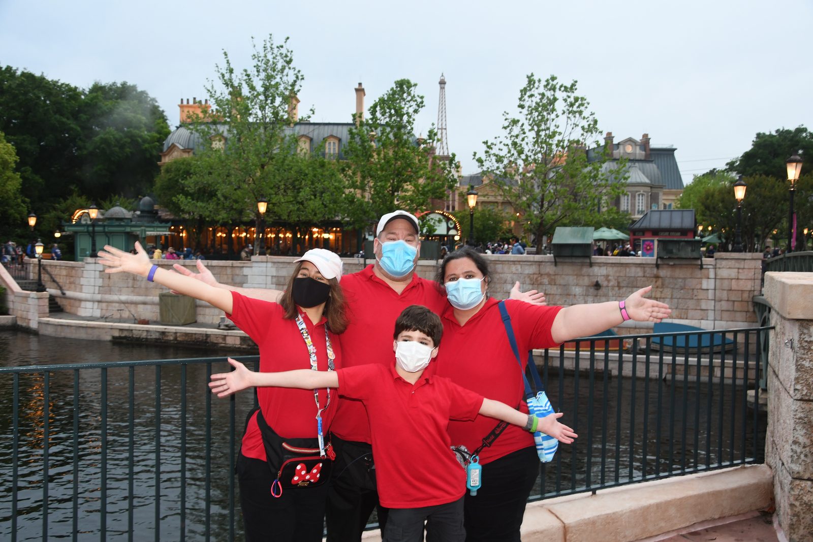 The four of us with arms out by the lagoon at dusk