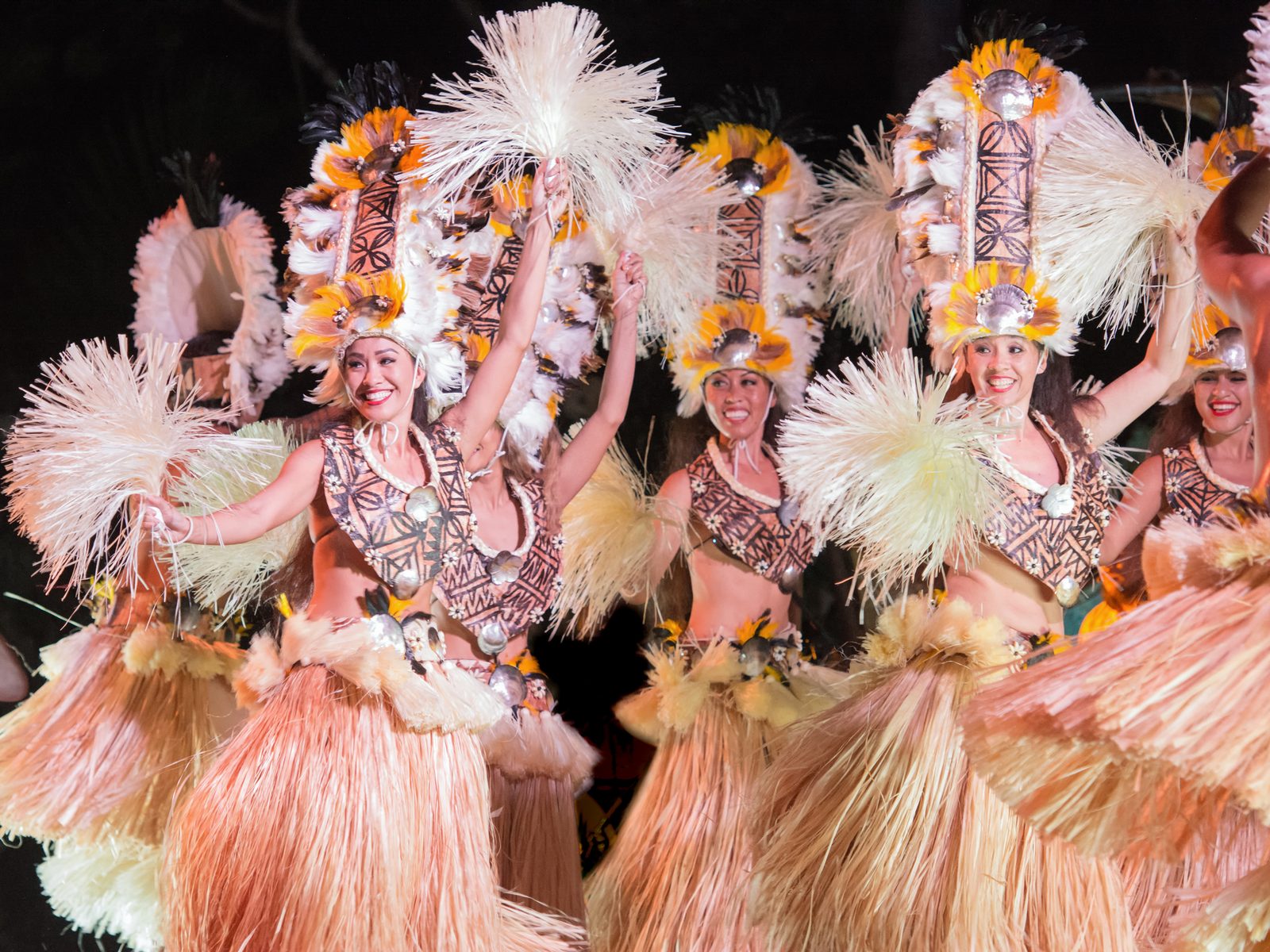 Dancers in feathered headdresses at the luau