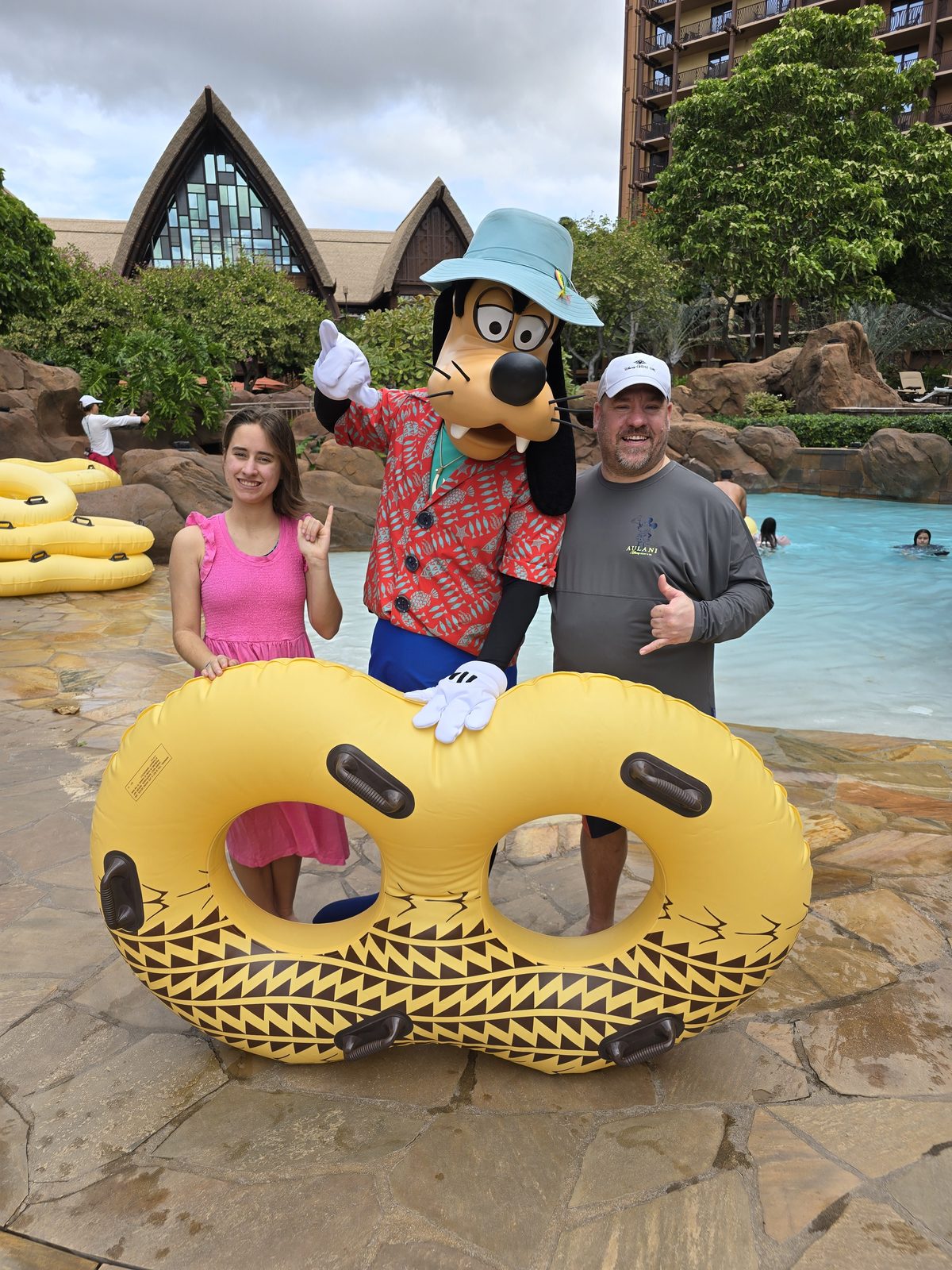 Lisa, Goofy in his aloha outfit and Michael at the Aulani pool