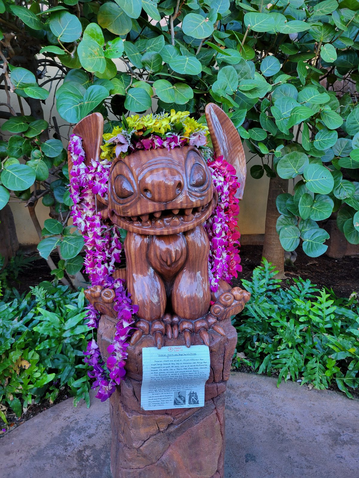 A carved tiki wearing leis