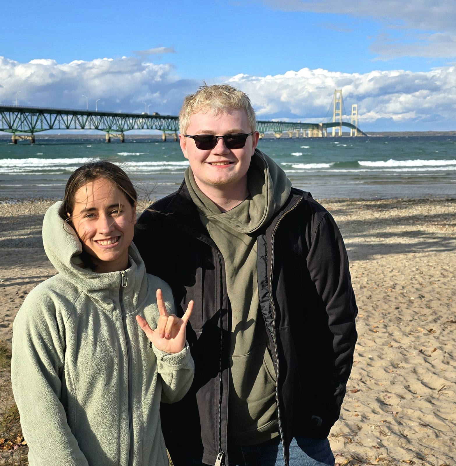 Lisa and a friend on the beach with the Mackinac Bridge behind them