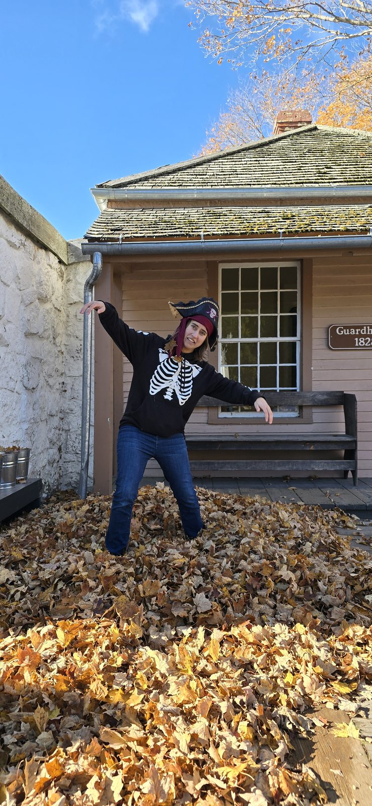 Lisa diving into a leaf pile in her skeleton hoodie