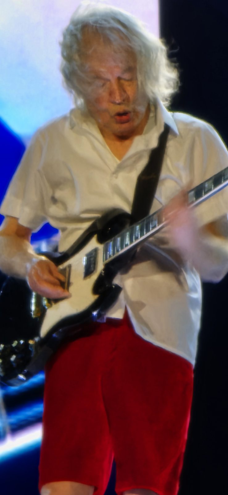 Angus Young works the stage in his schoolboy uniform