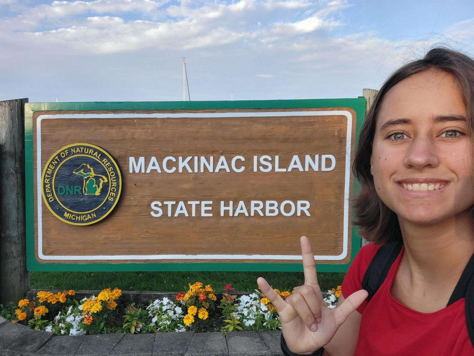 Lisa signs I love you at the harbor sign