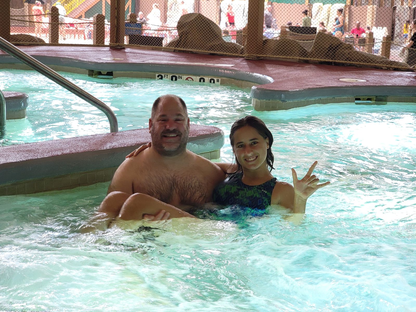 Lisa and Michael making rock signs in the hot tub