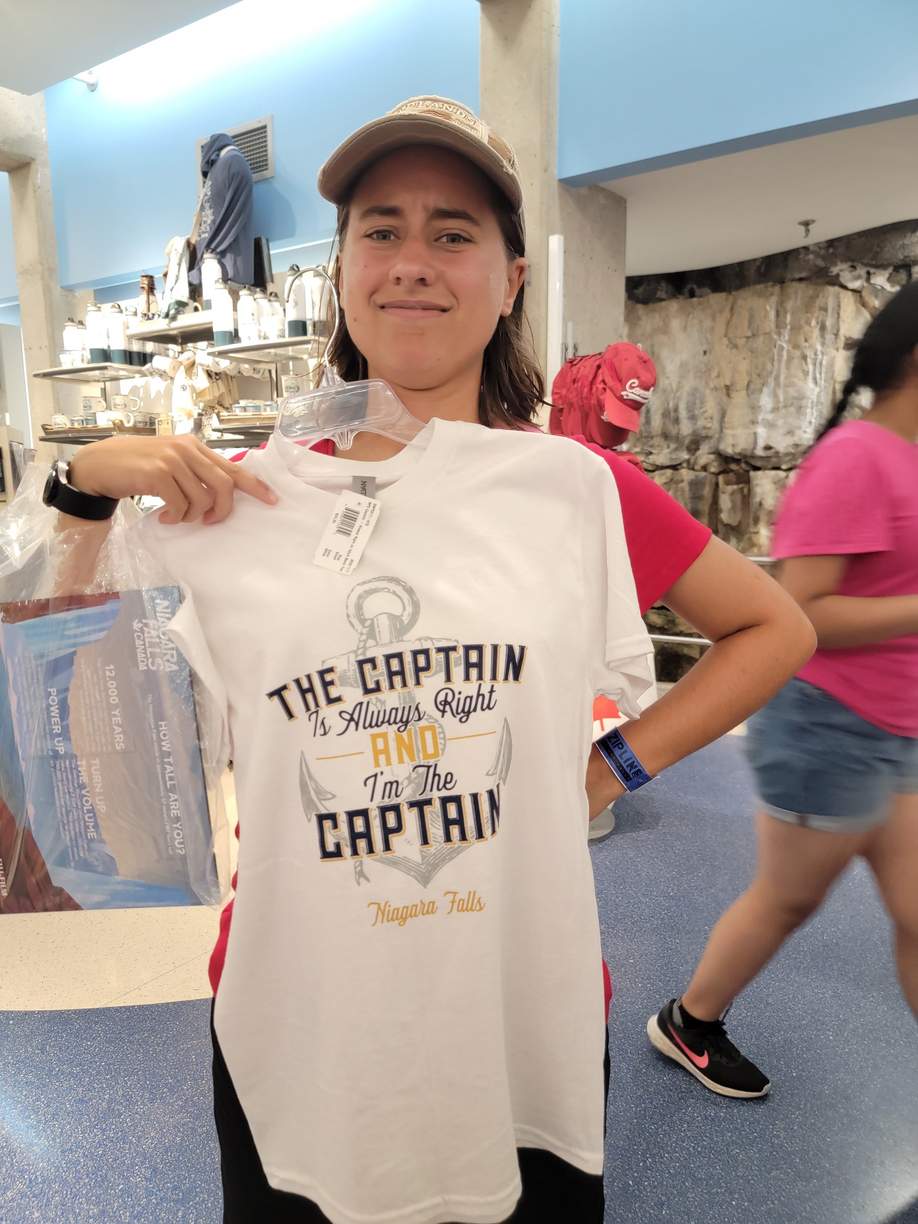 Lisa holding up the Captain shirt in the gift shop