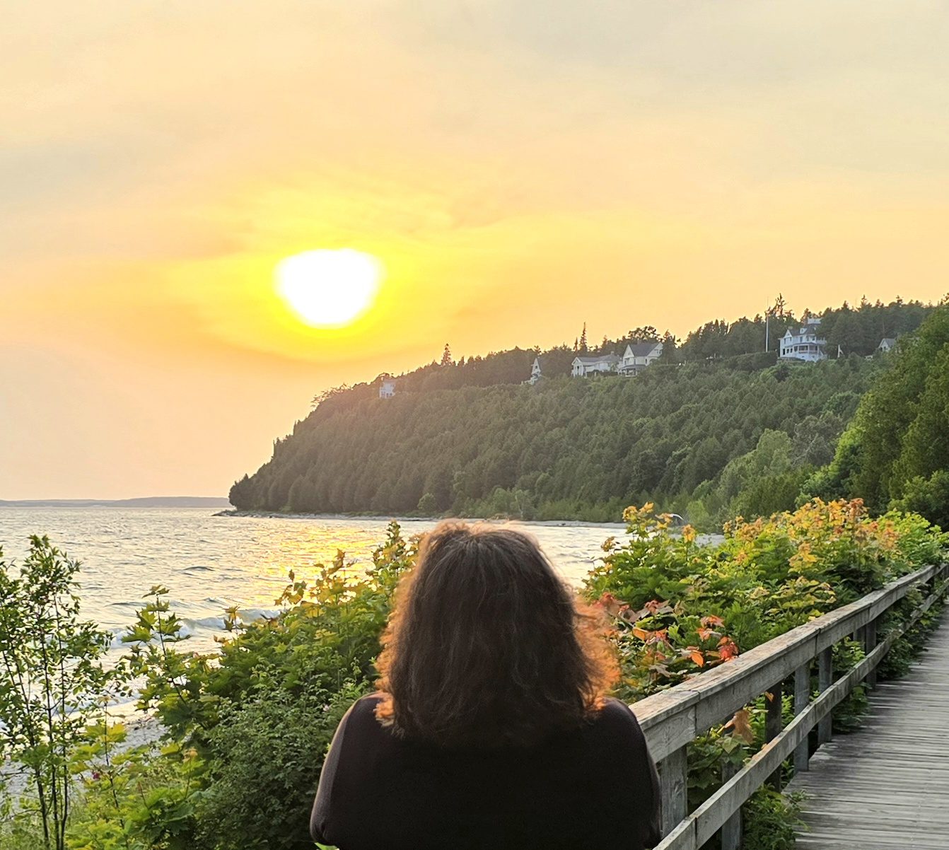Kathy watches the sun go down over the water