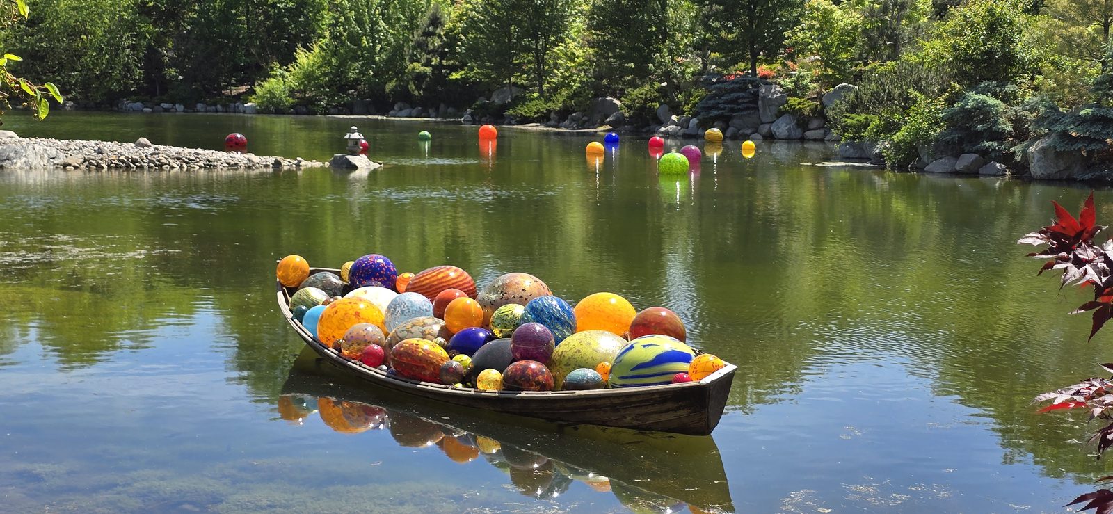 A boat full of Chihuly glass on the pond