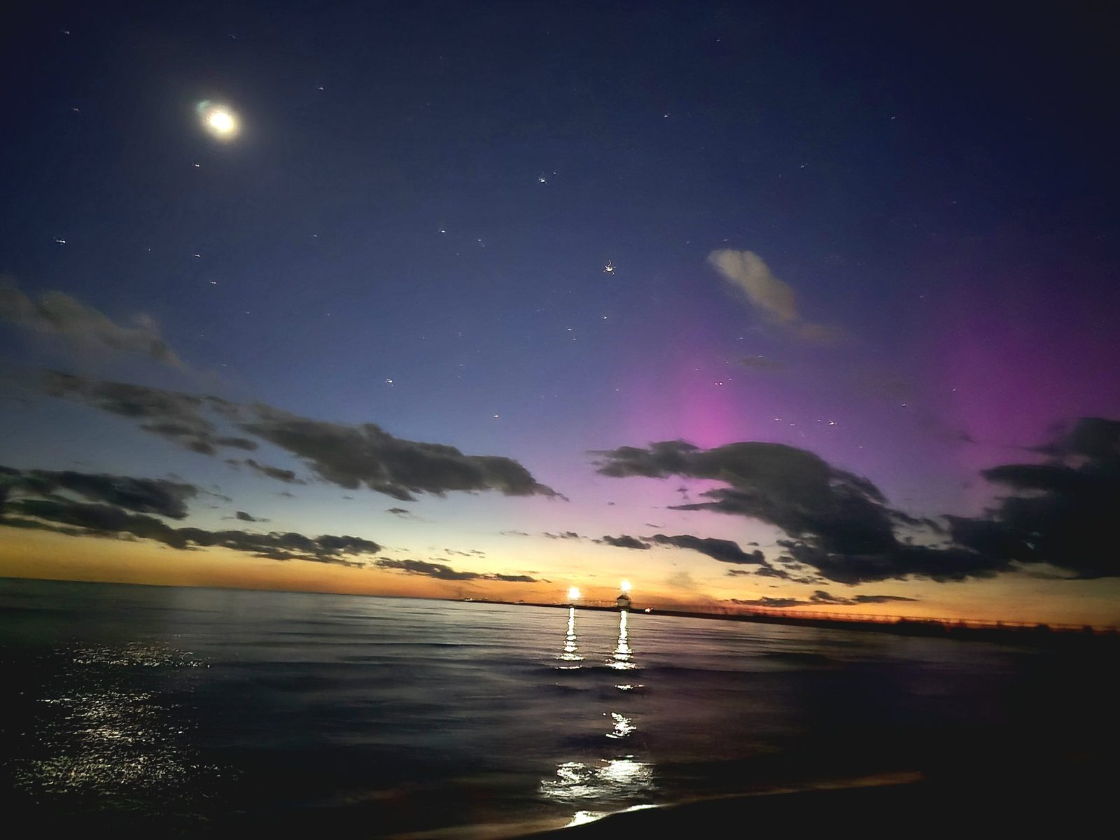 The moon and a purple aurora over the water