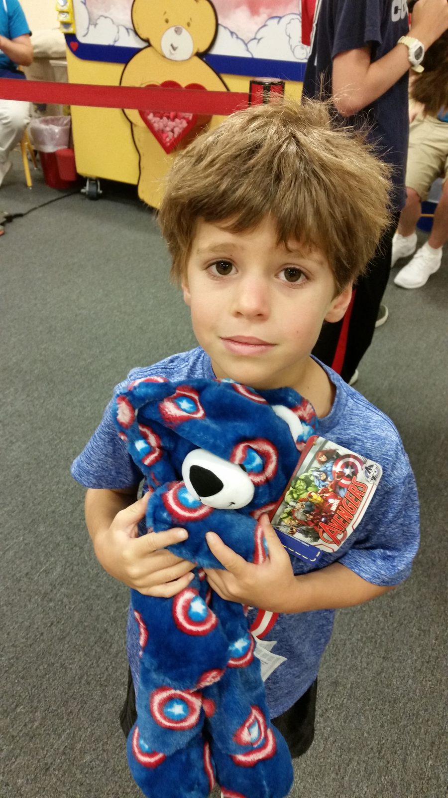 Thomas holds the stuffed bear he just picked out