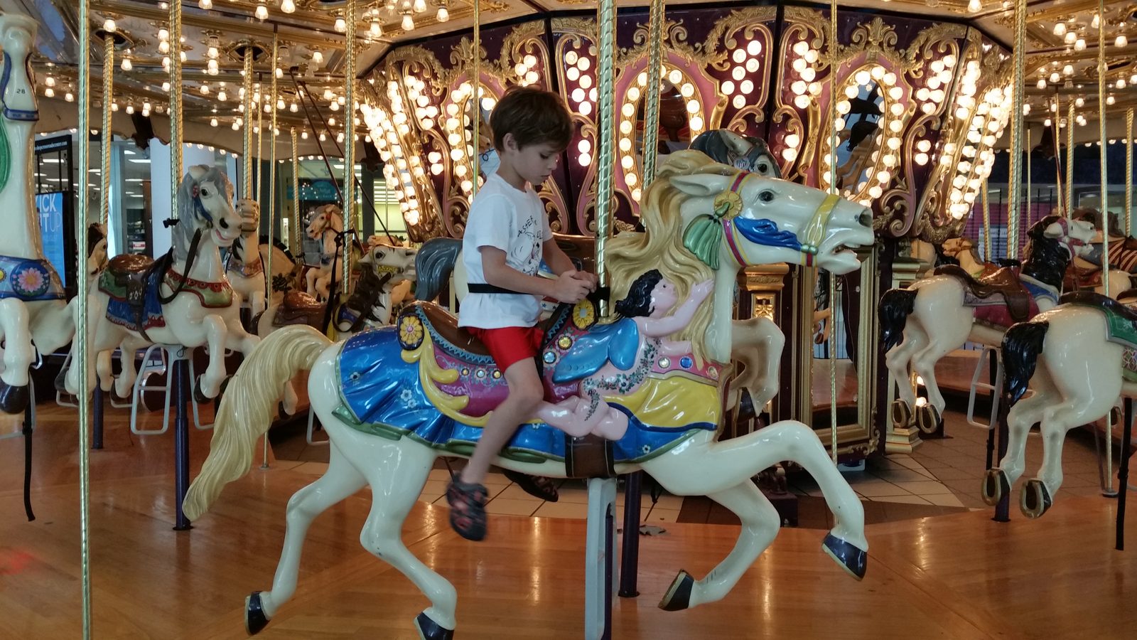 Thomas climbs onto the carousel horse