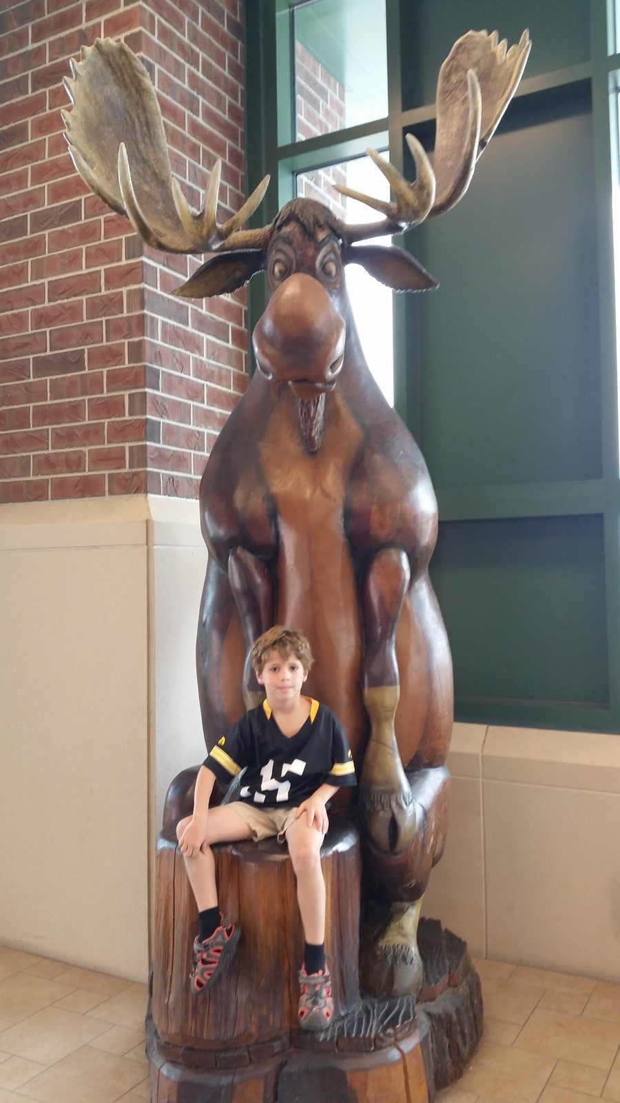Thomas climbs the bronze moose statue