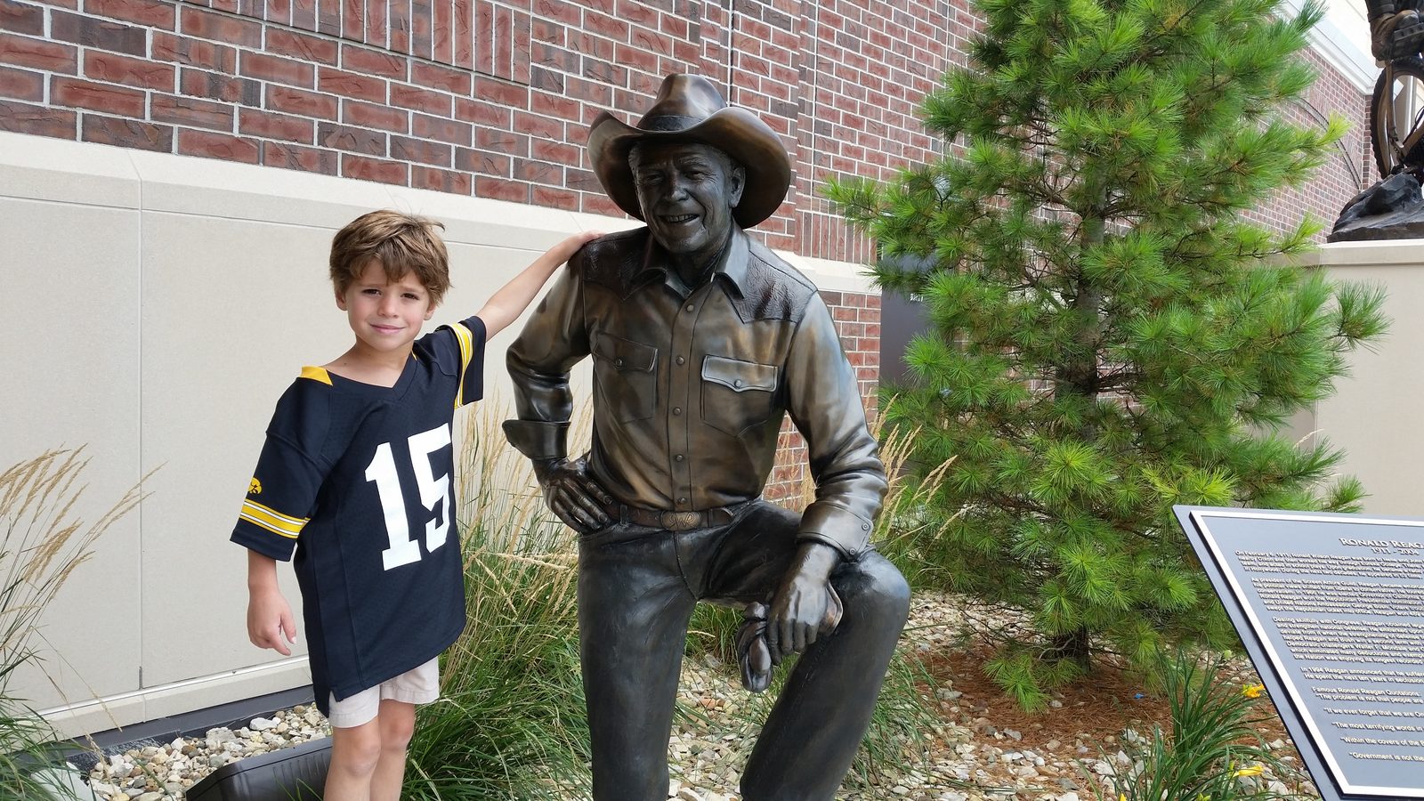 Thomas with a bronze statue outside Scheels