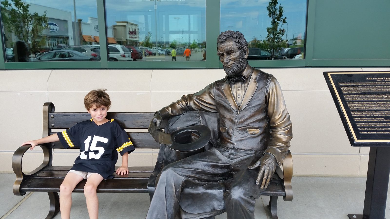 Thomas on the bench with a statue at Scheels