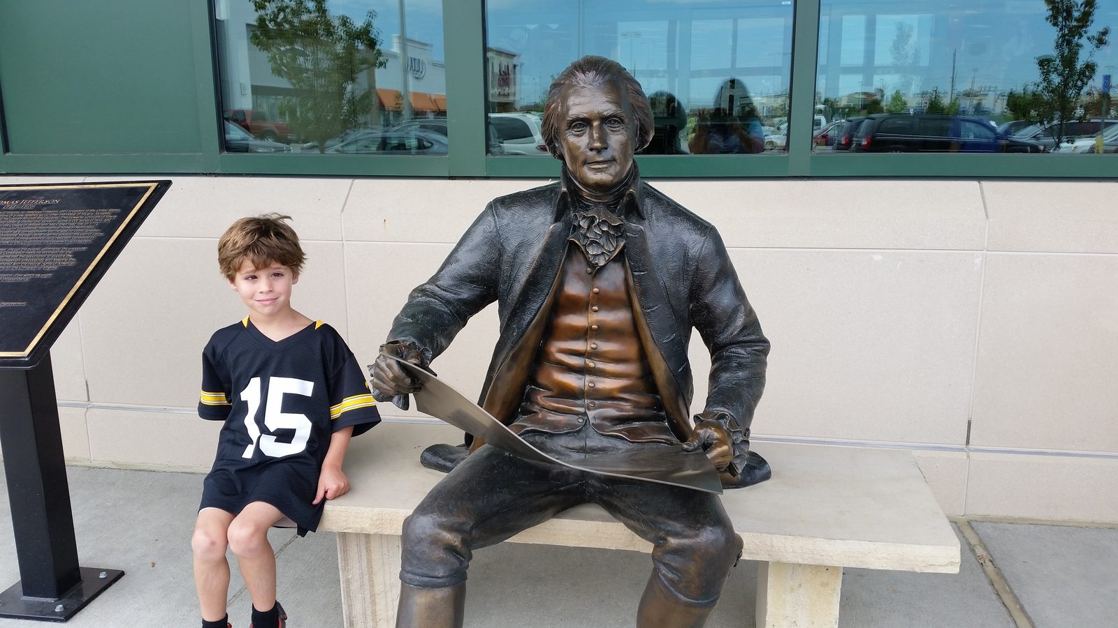 Thomas sitting beside another statue at Scheels