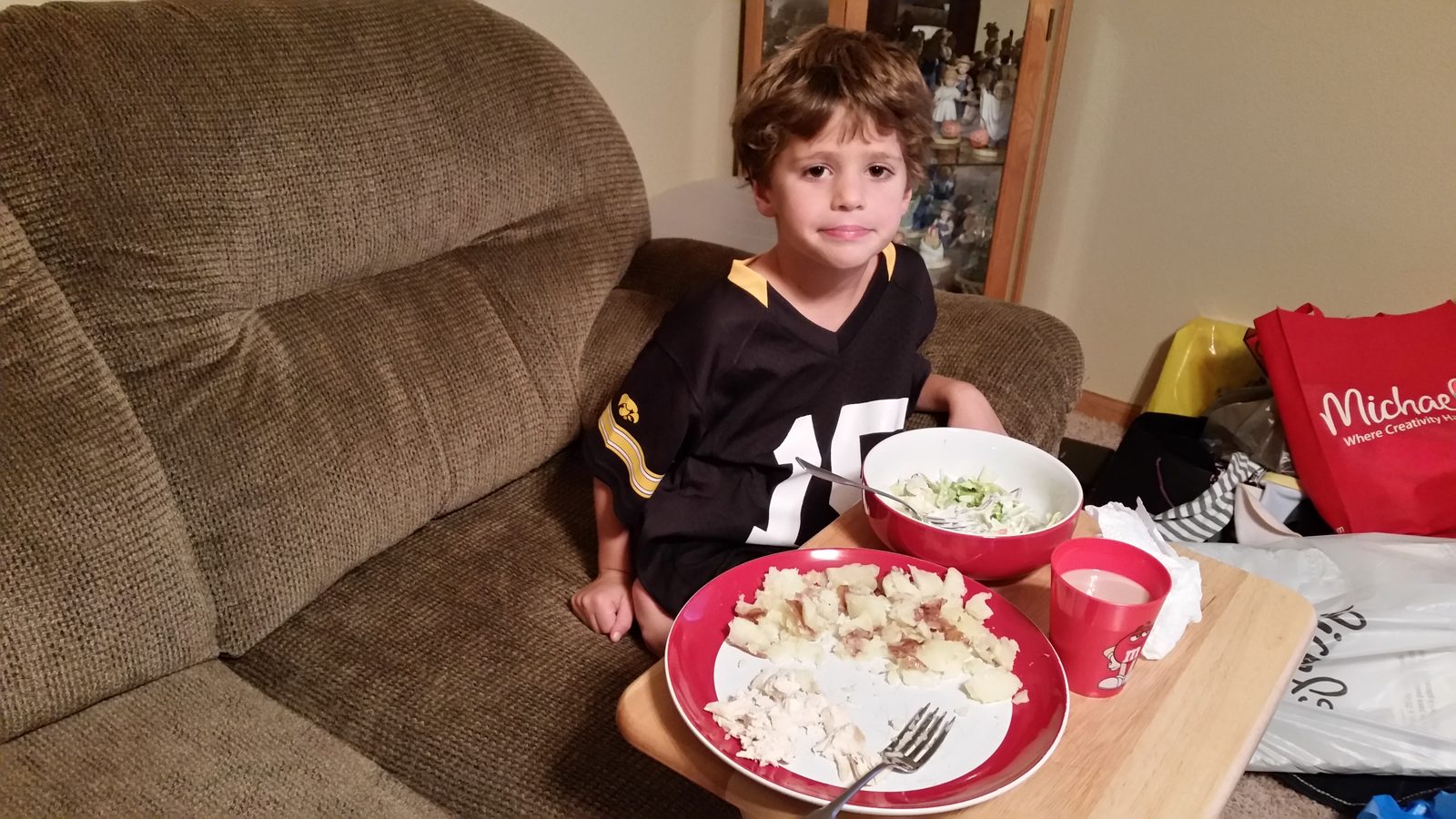 Thomas has dinner in the recliner, plate on his lap