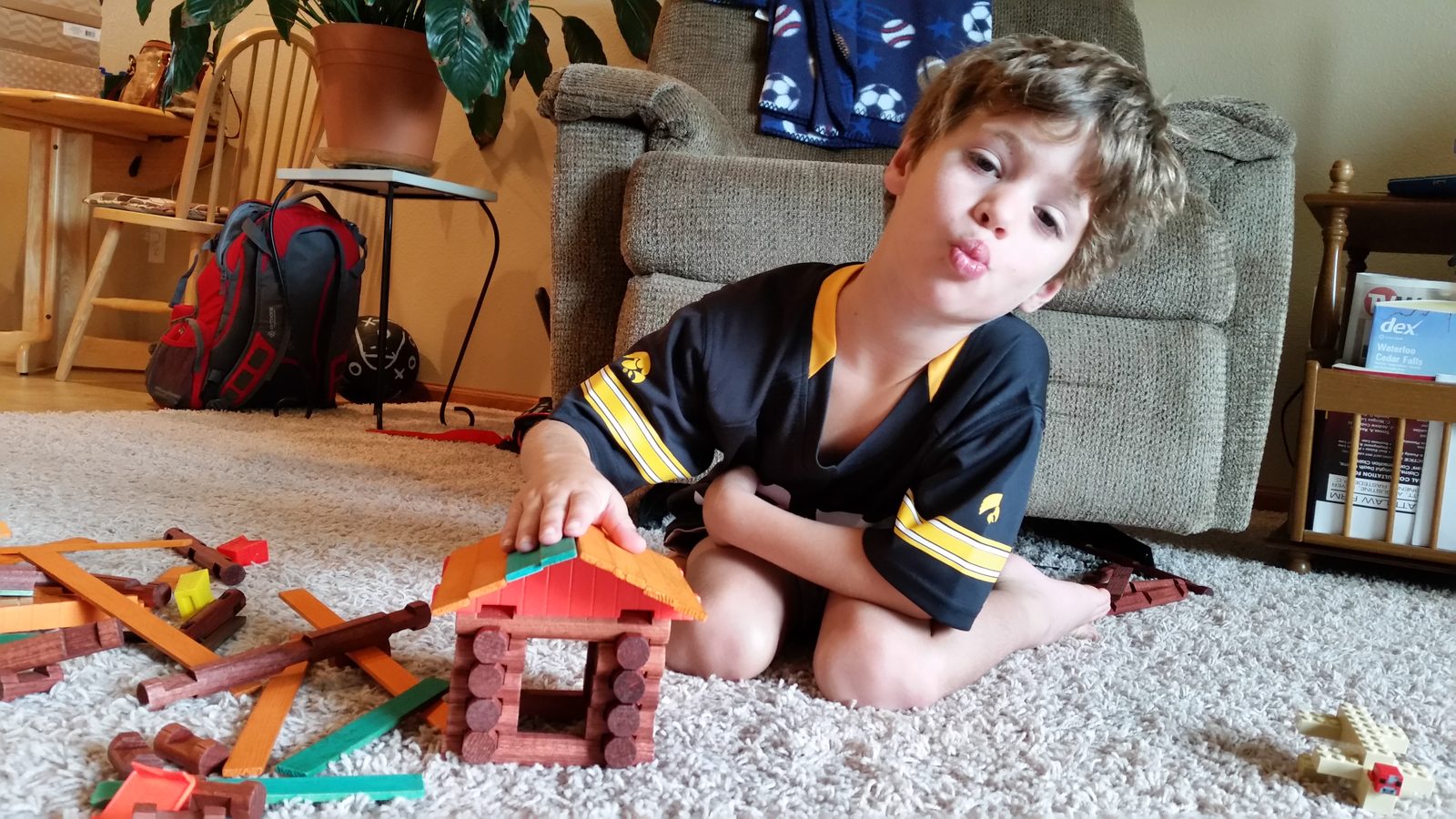 Thomas makes a silly face while building with Lincoln Logs