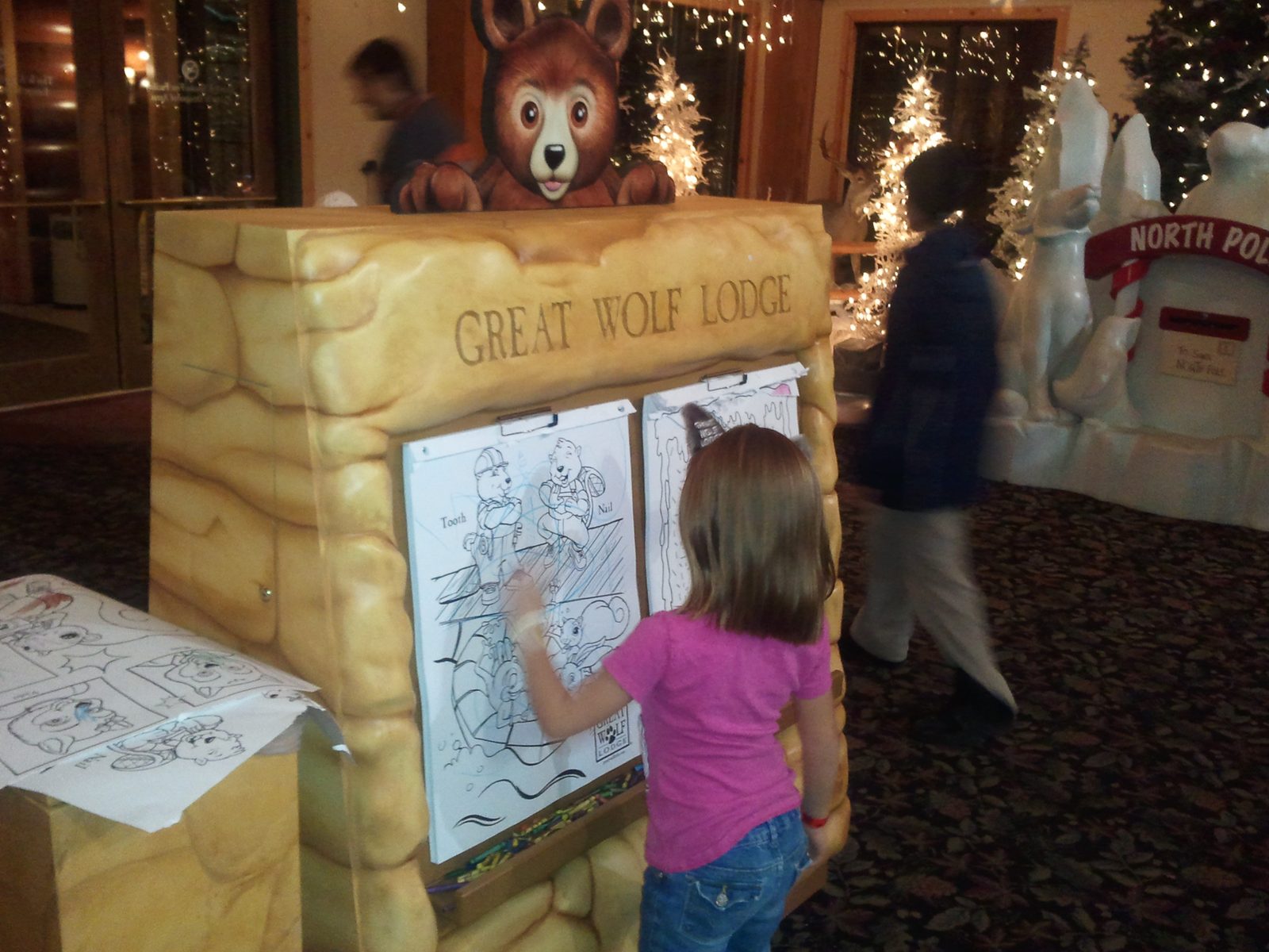 Lisa colors at a table near the lodge mascot