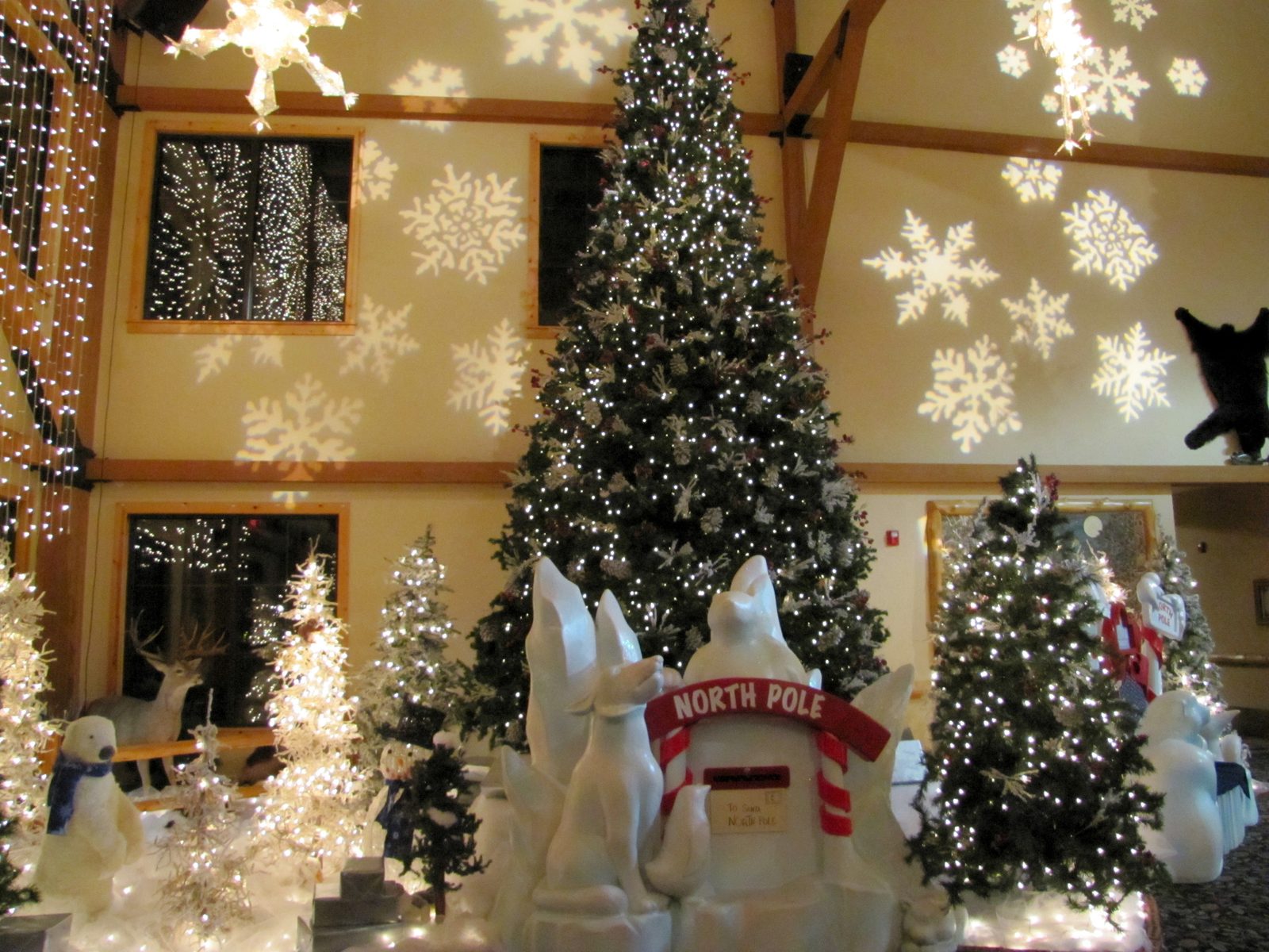 Christmas trees lit in the great room, snowflakes on the wall