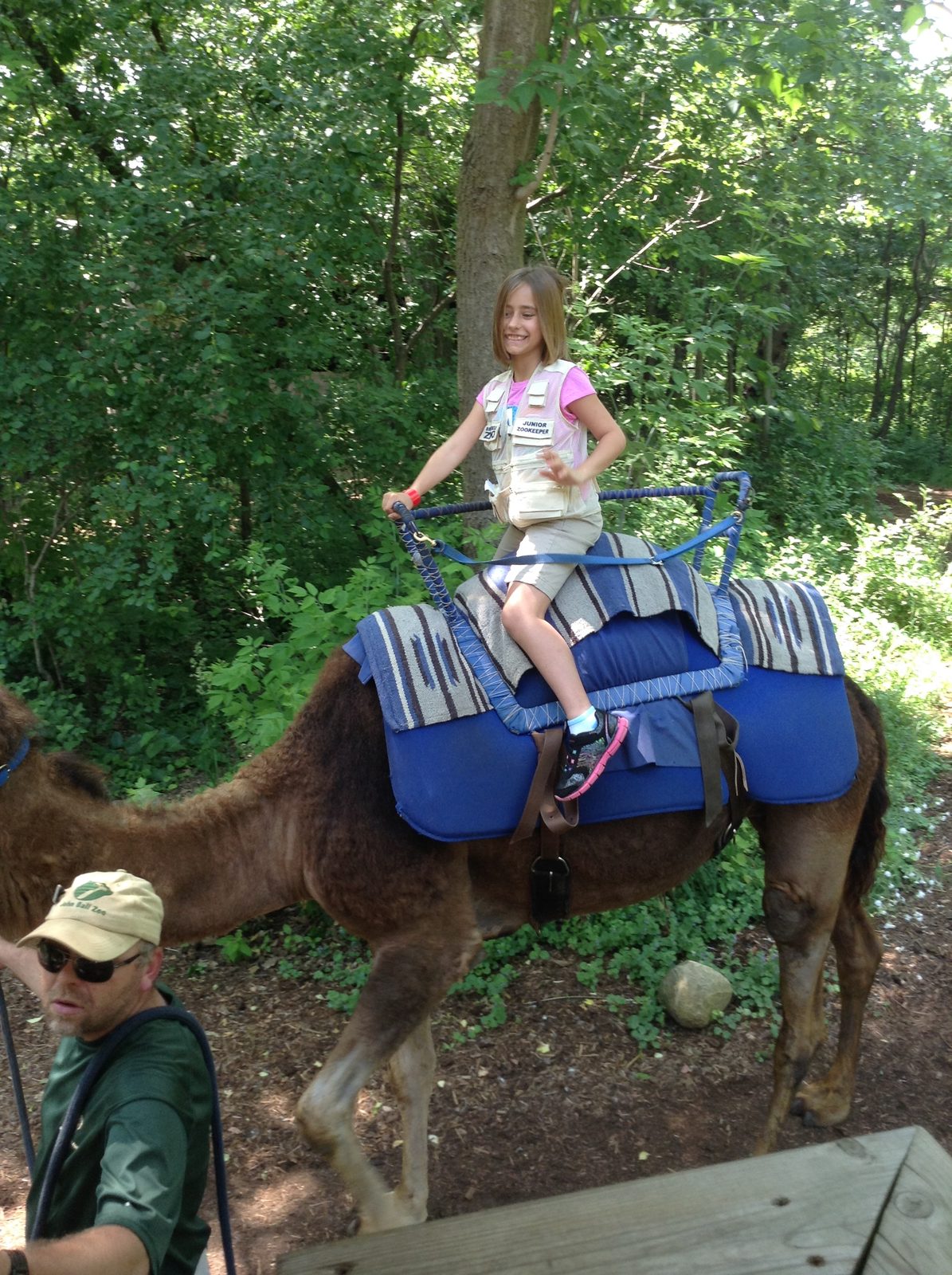 Lisa riding the camel through the woods