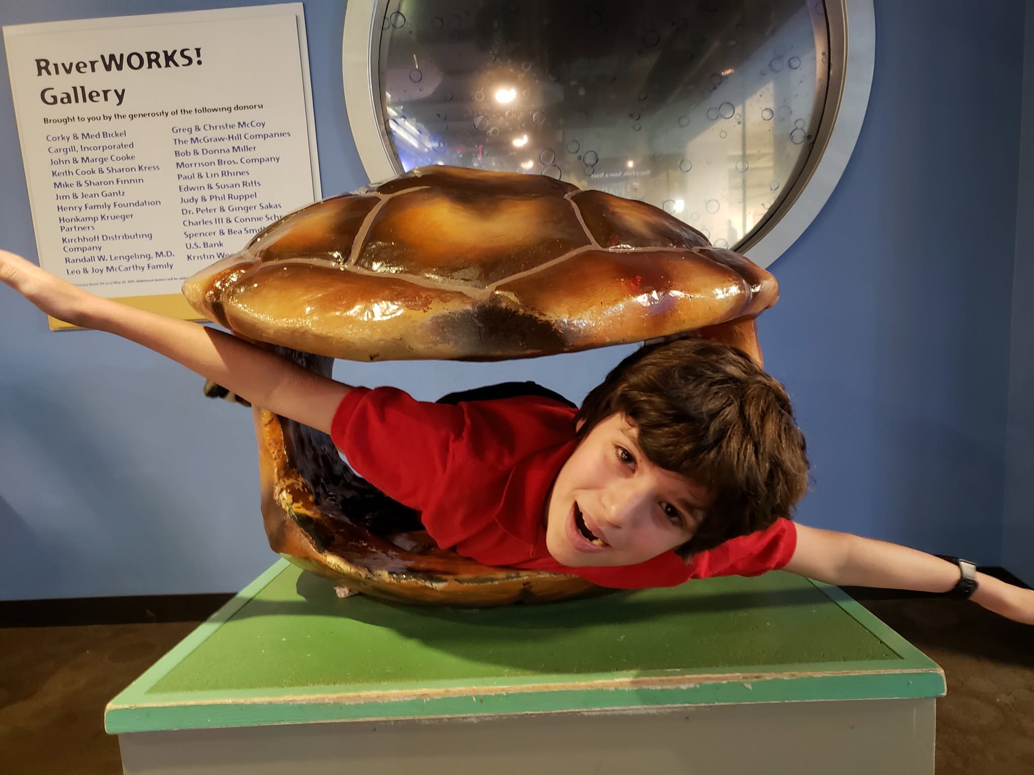 Thomas trying on a turtle shell at the river museum