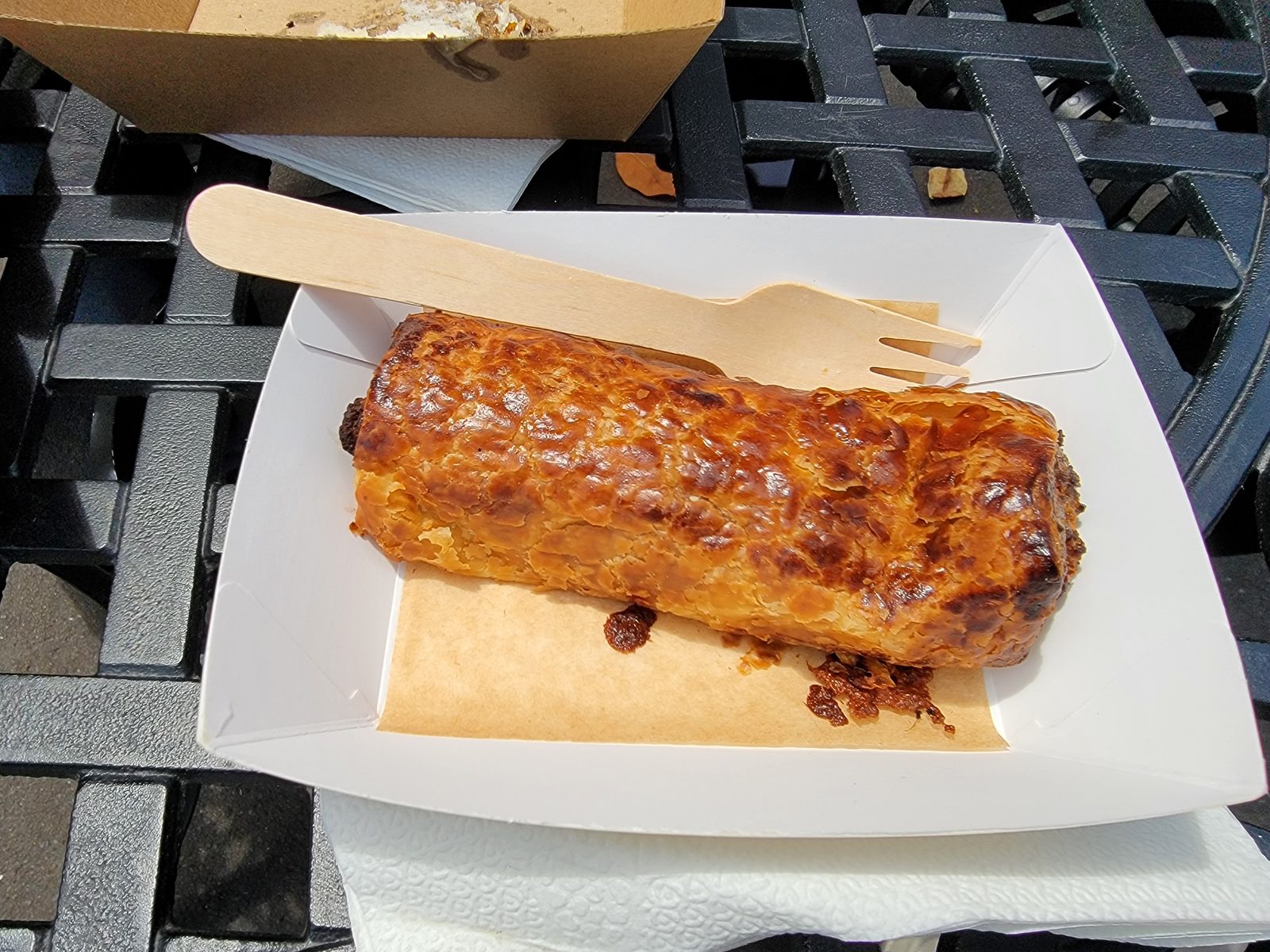 A sausage roll and a bamboo fork in the botanic garden