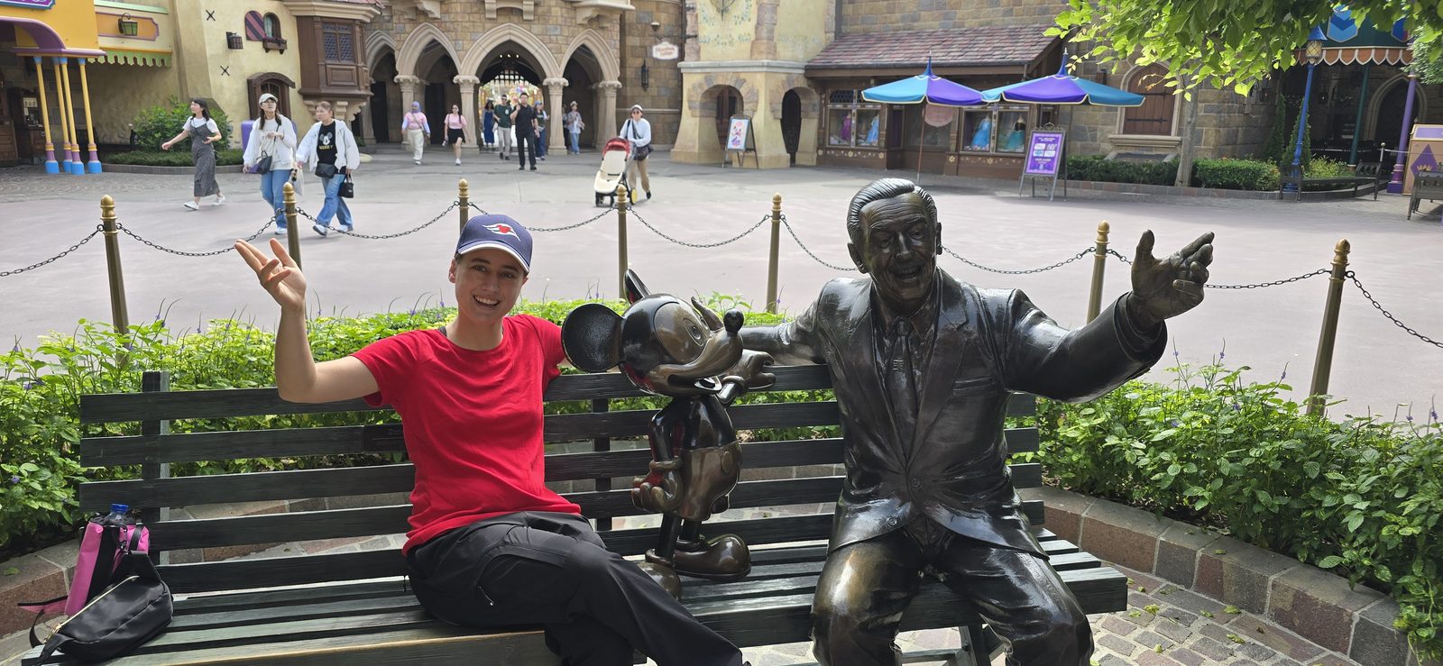 Lisa on the bench with the Walt statue at Hong Kong Disneyland