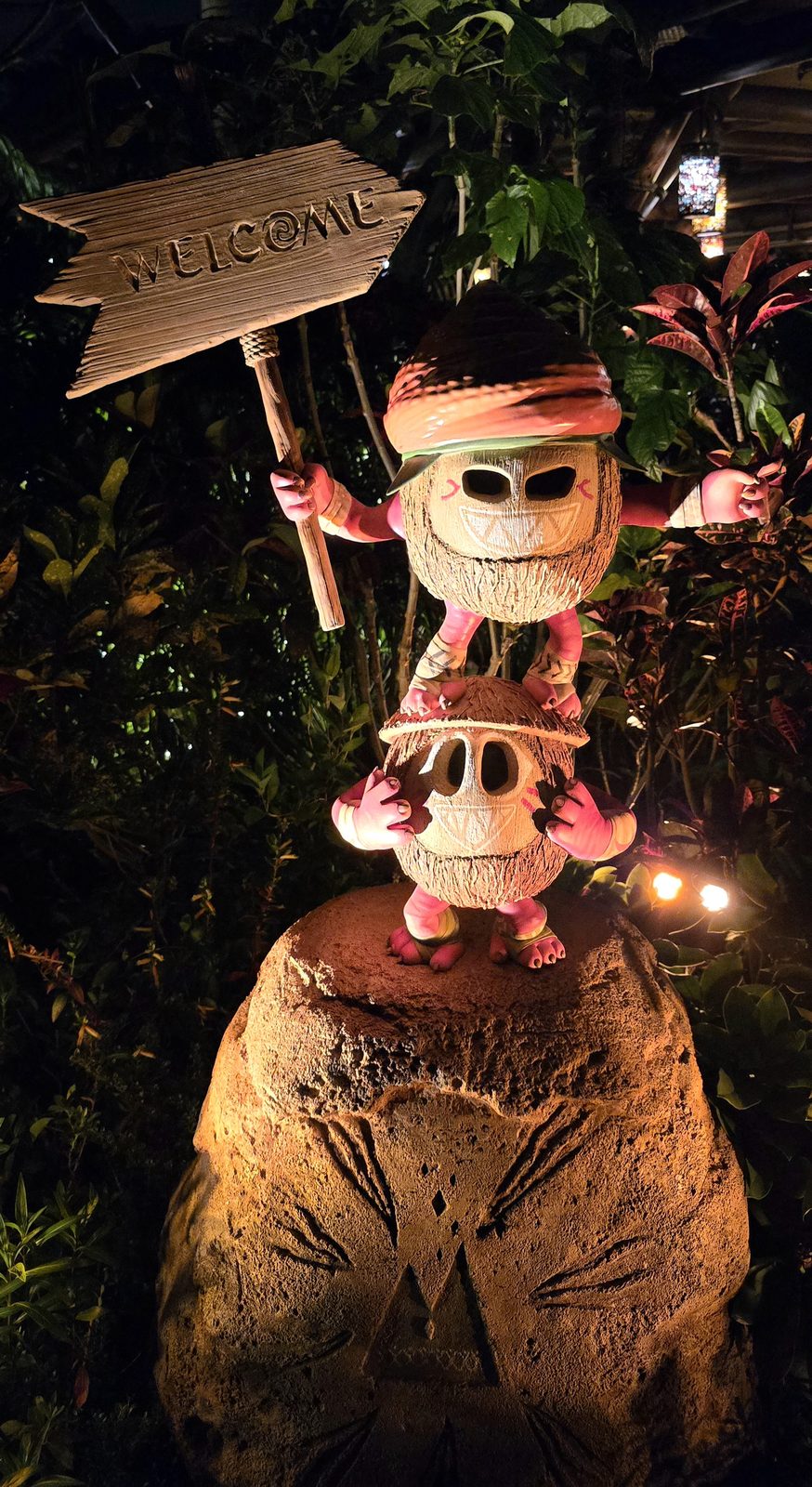 A welcome sign in the jungle after dark at Hong Kong Disneyland