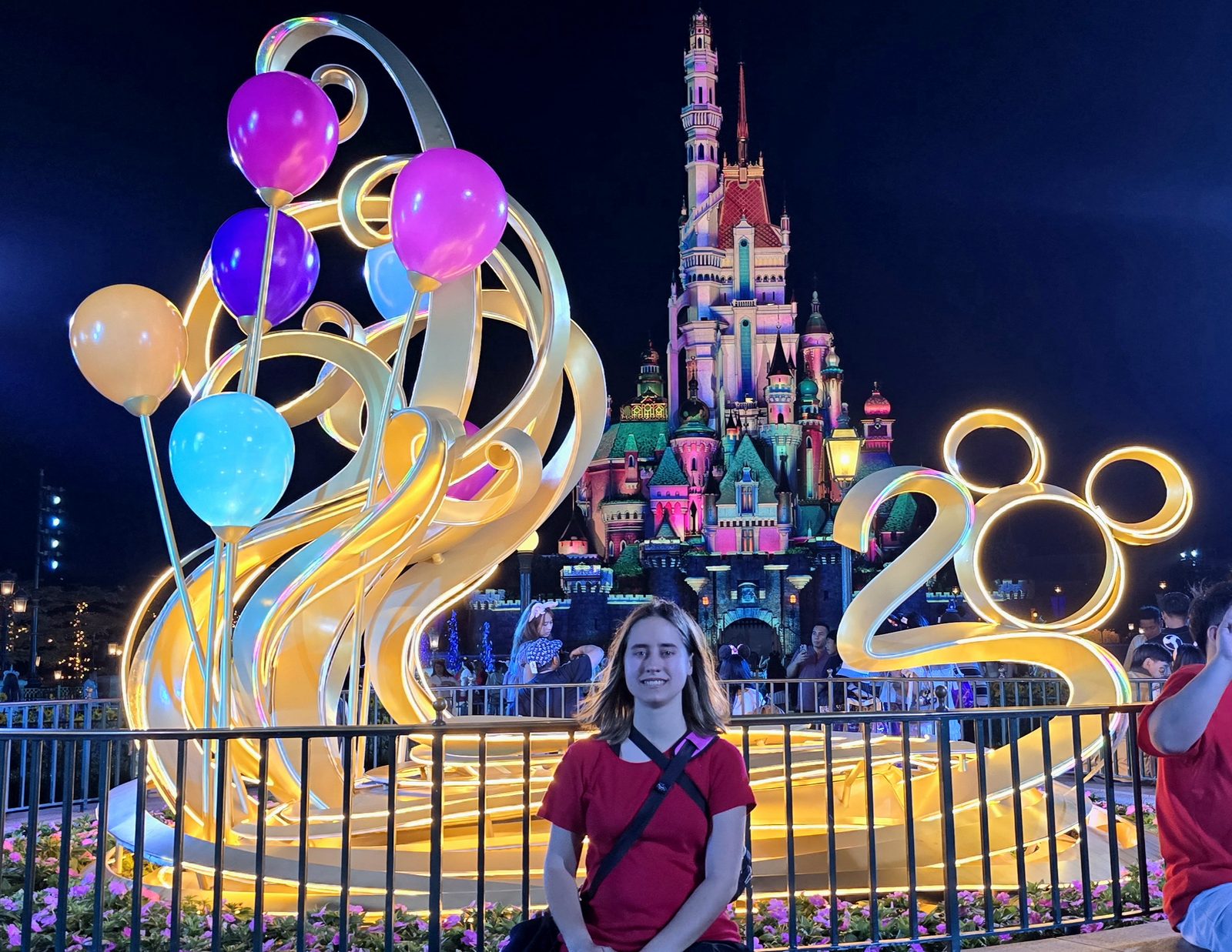 Lisa under the lit castle at night