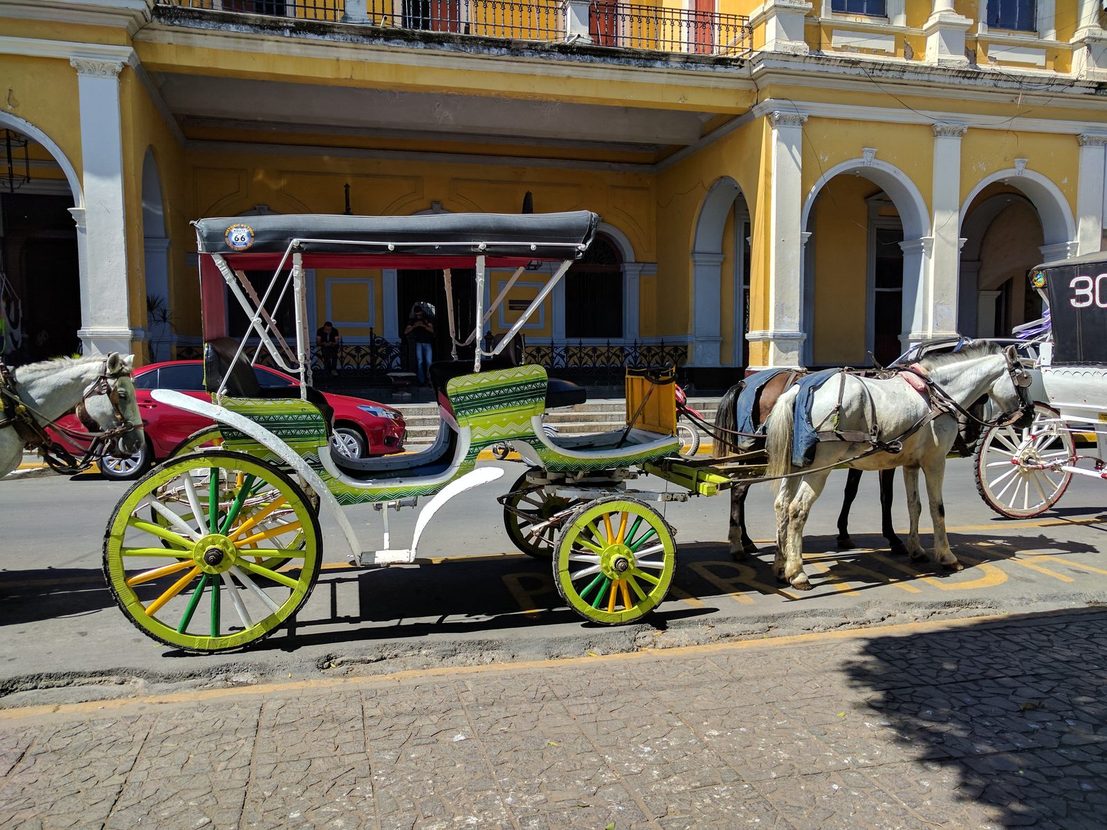 A horse-drawn carriage outside a yellow building