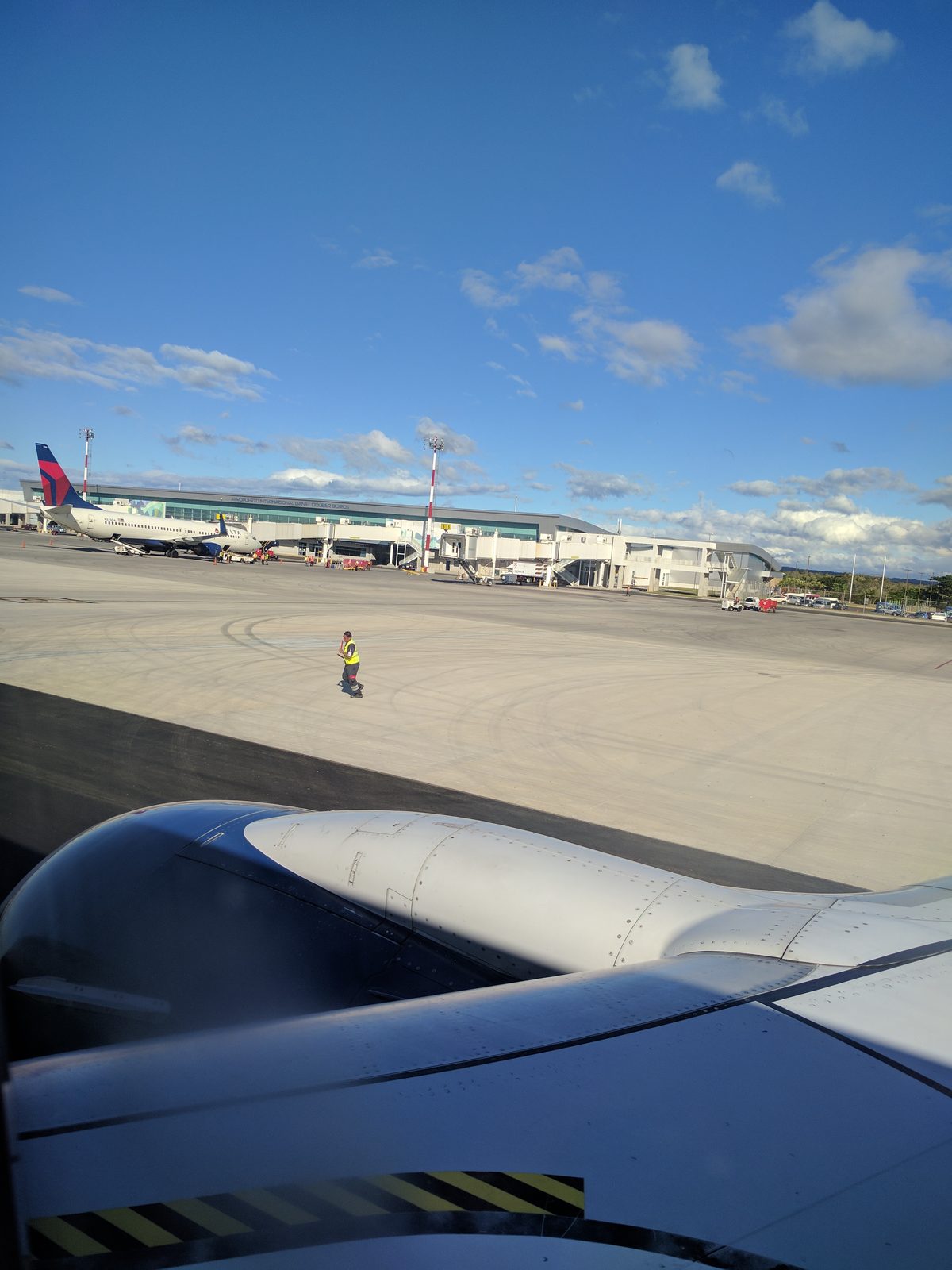 Out the window at the airport, wing in the foreground